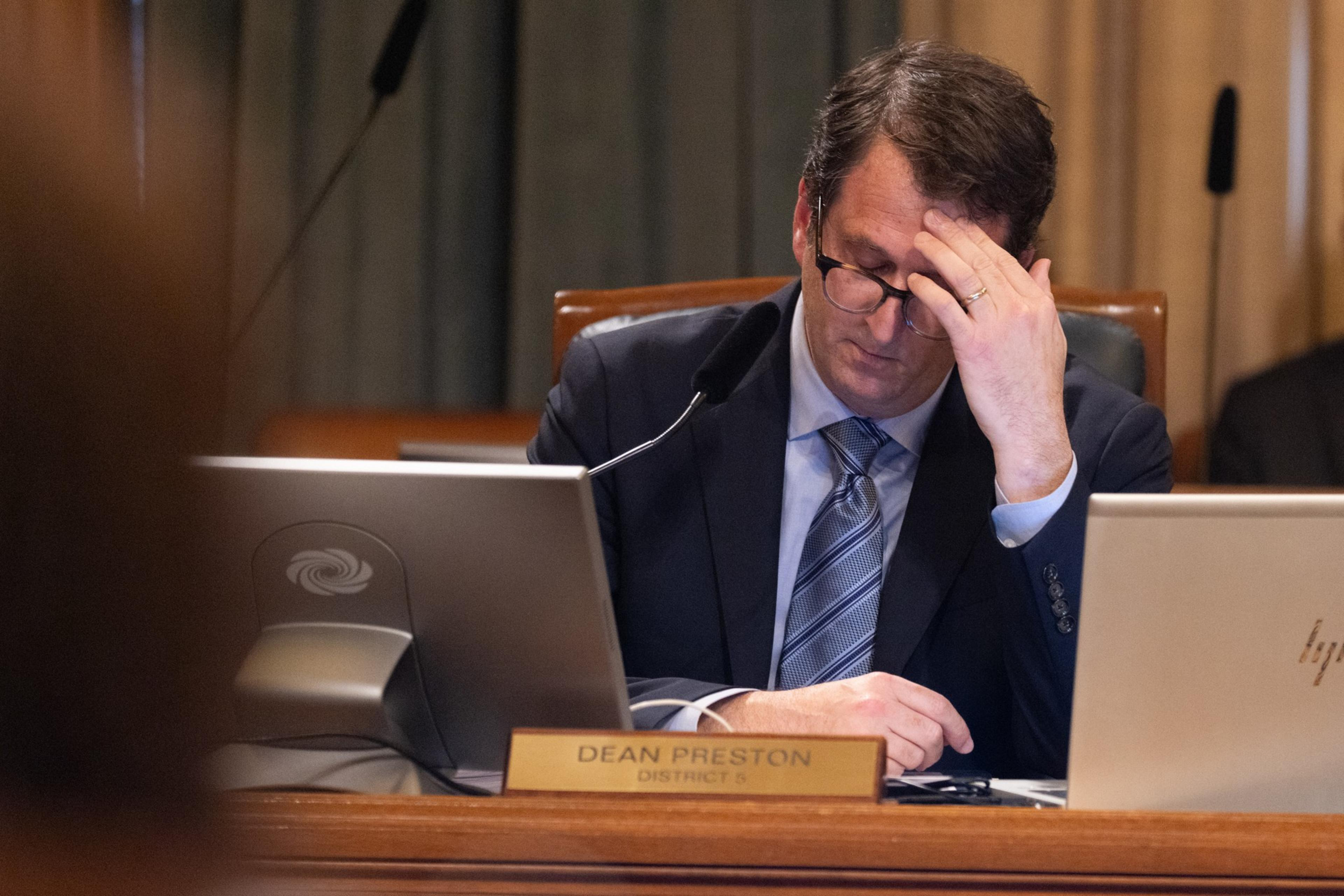 Supervisor Dean Preston looking down with his hand on his head during public comment at City Hall.