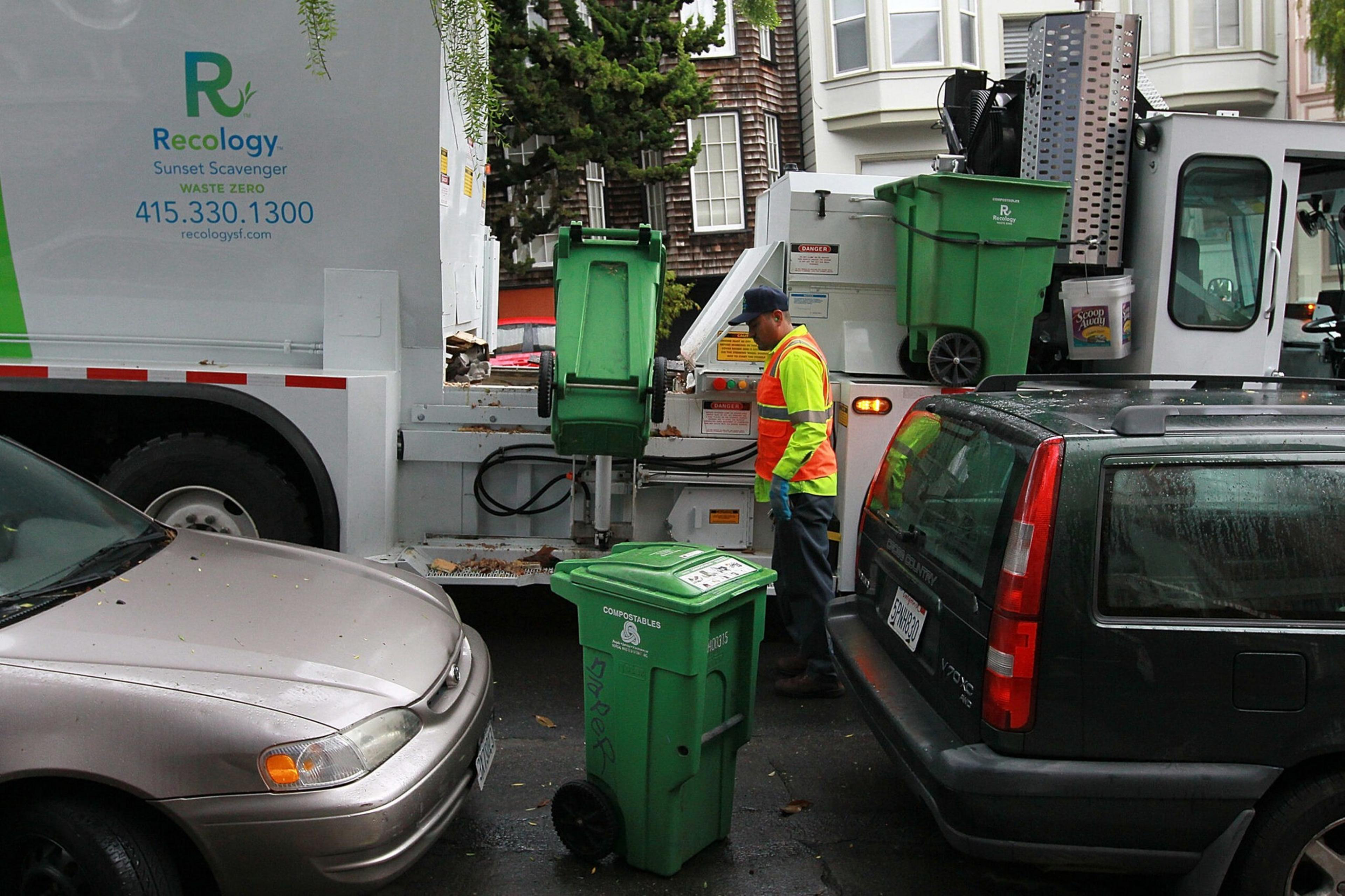 A Recology worker loads compost into a truck in San Francisco.