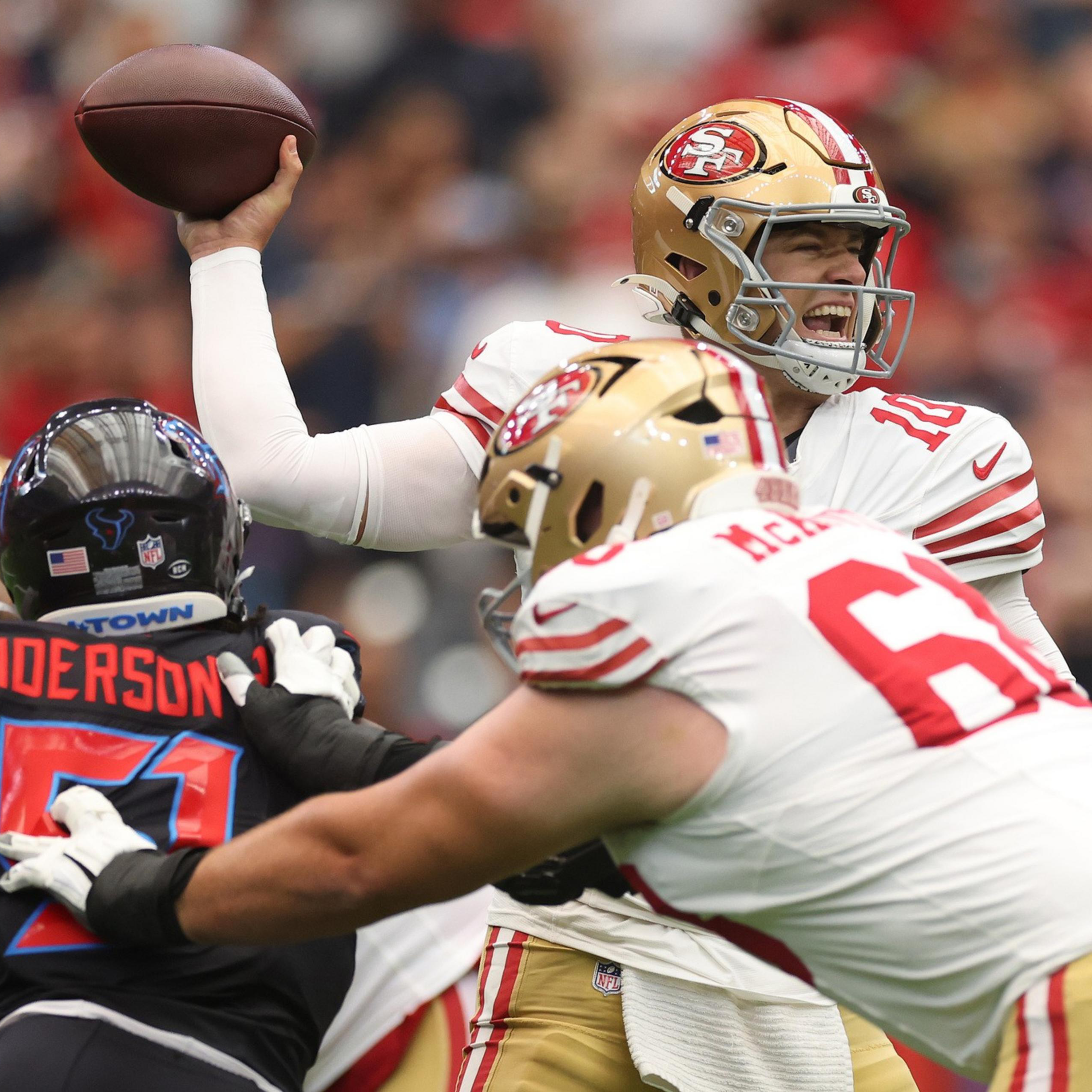 A San Francisco 49ers quarterback prepares to throw a pass while his offensive lineman blocks a Houston Texans defender.
