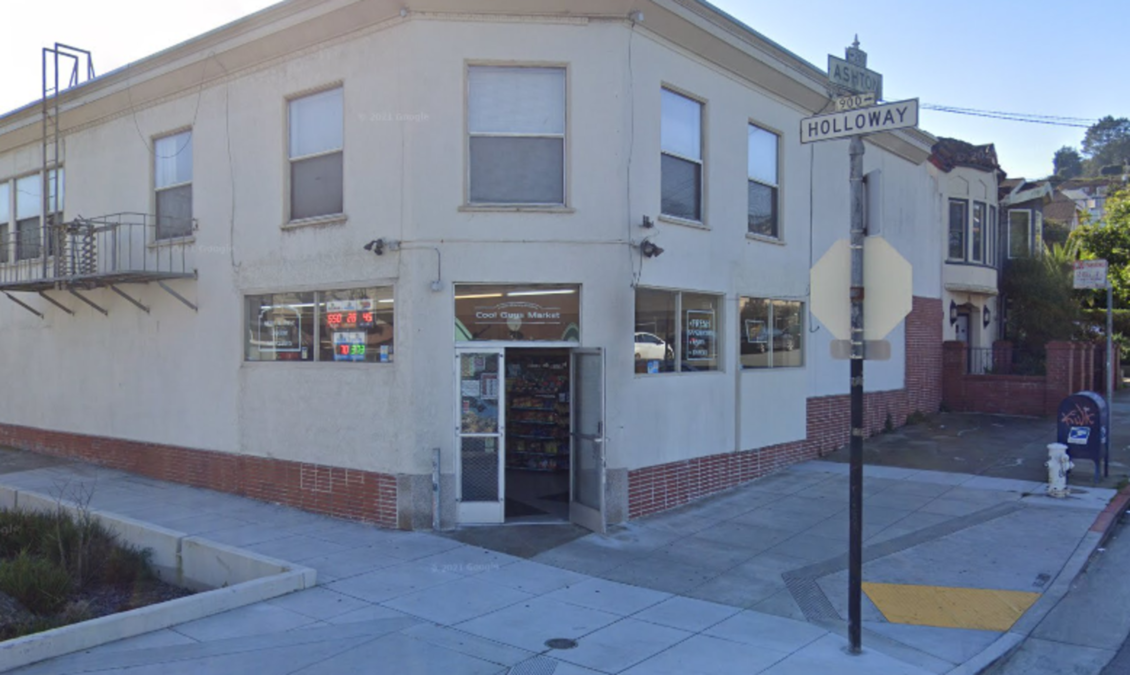 A beige and red brick building at the corner of an intersection