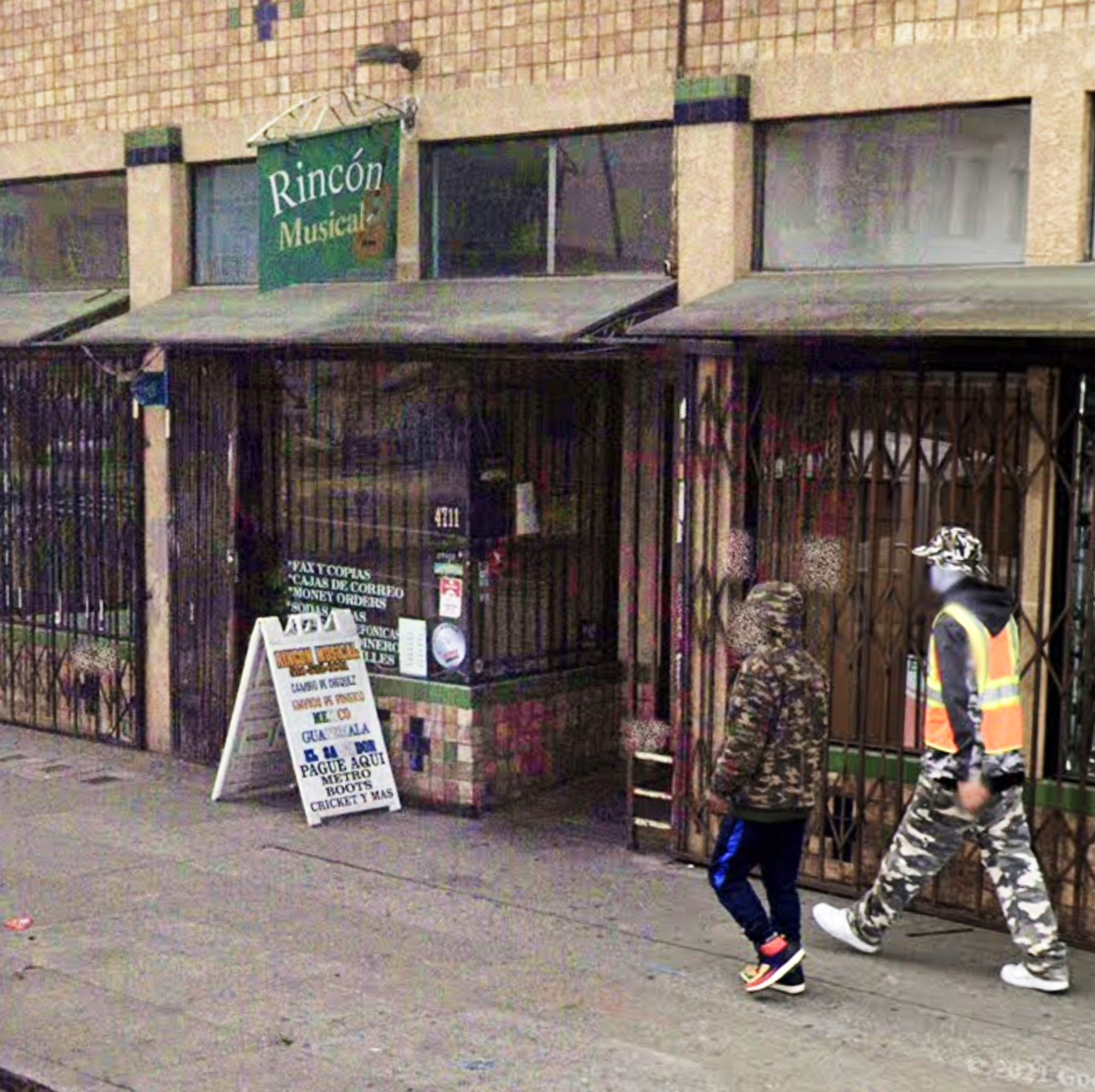 A man walks past a store. 