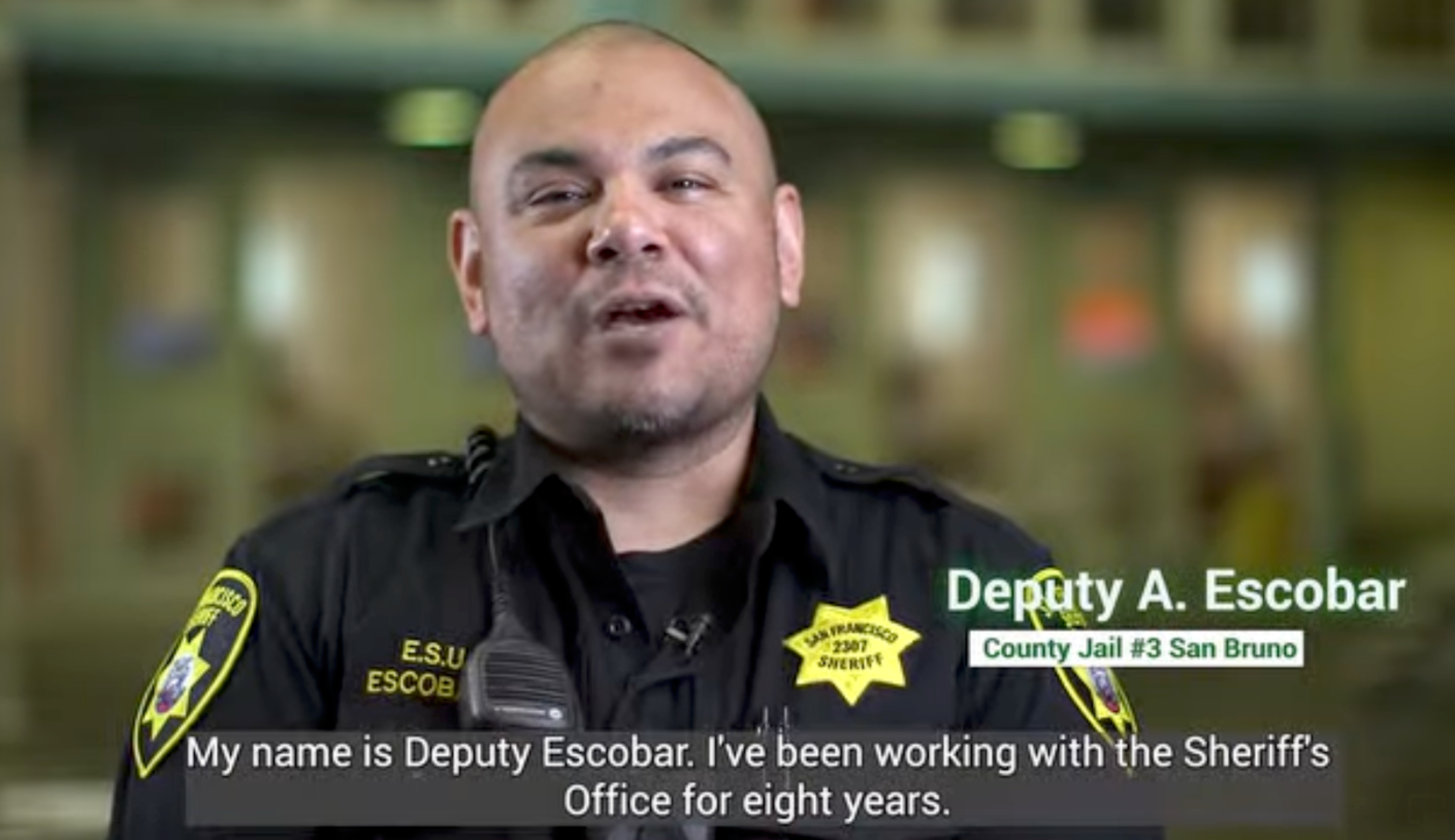 Deputy A. Escobar, wearing a sheriff’s uniform with a San Francisco patch, introduces himself and says he’s worked with the Sheriff’s Office for eight years.