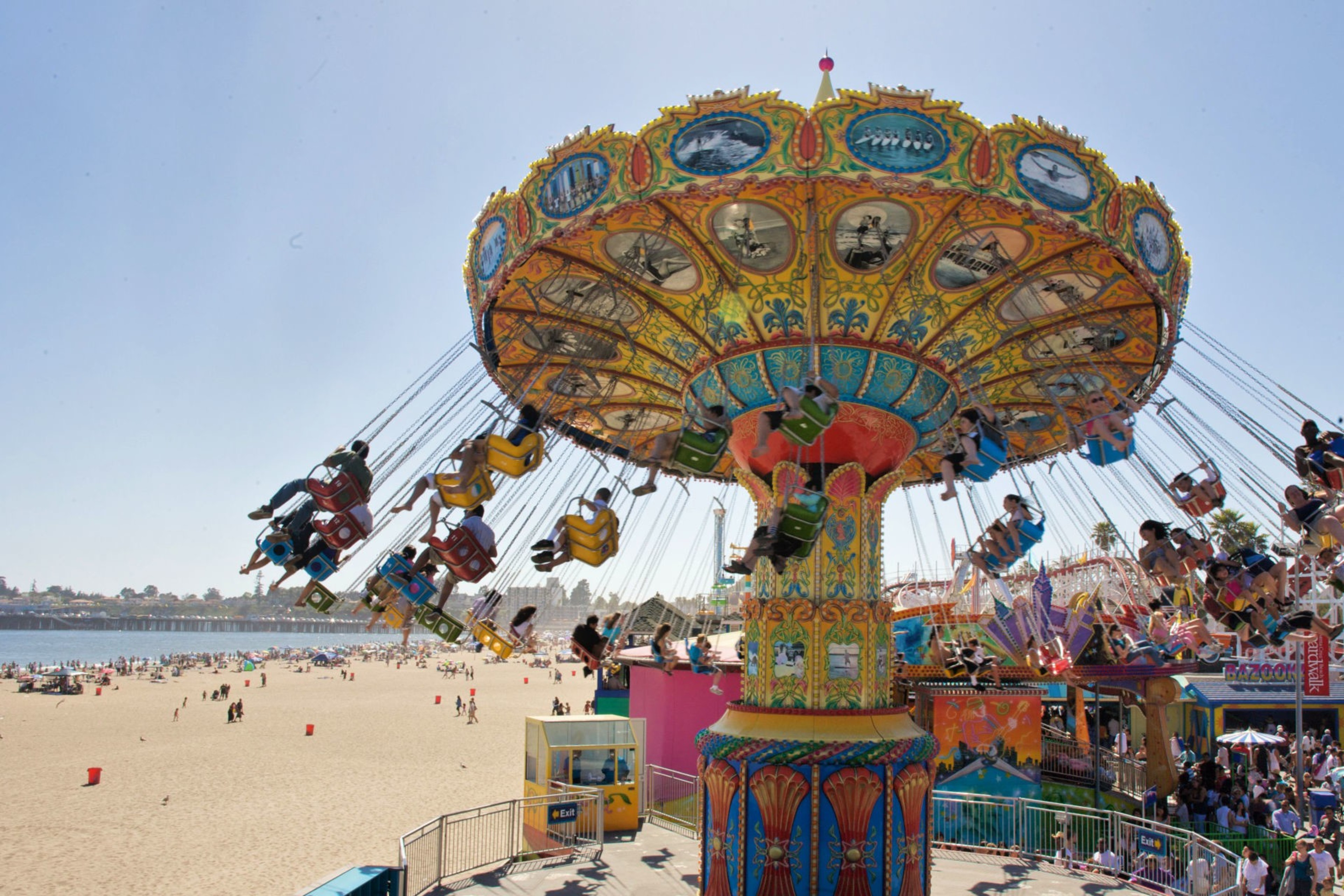 People ride in suspended chairs over the beach in Santa Cruz.