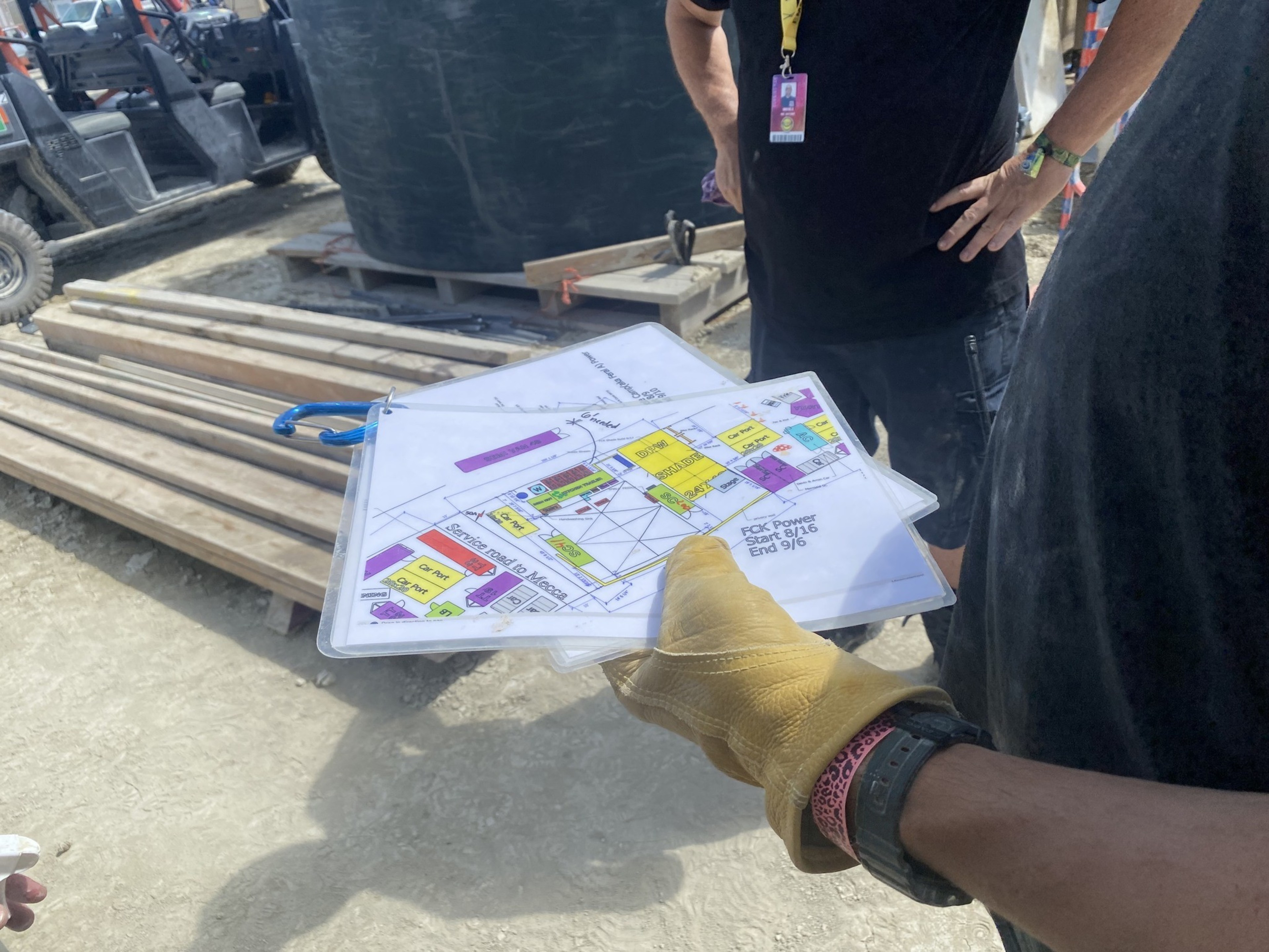 Builders at Burning Man 2023 consult plans for constructing a camp in the Nevada desert.