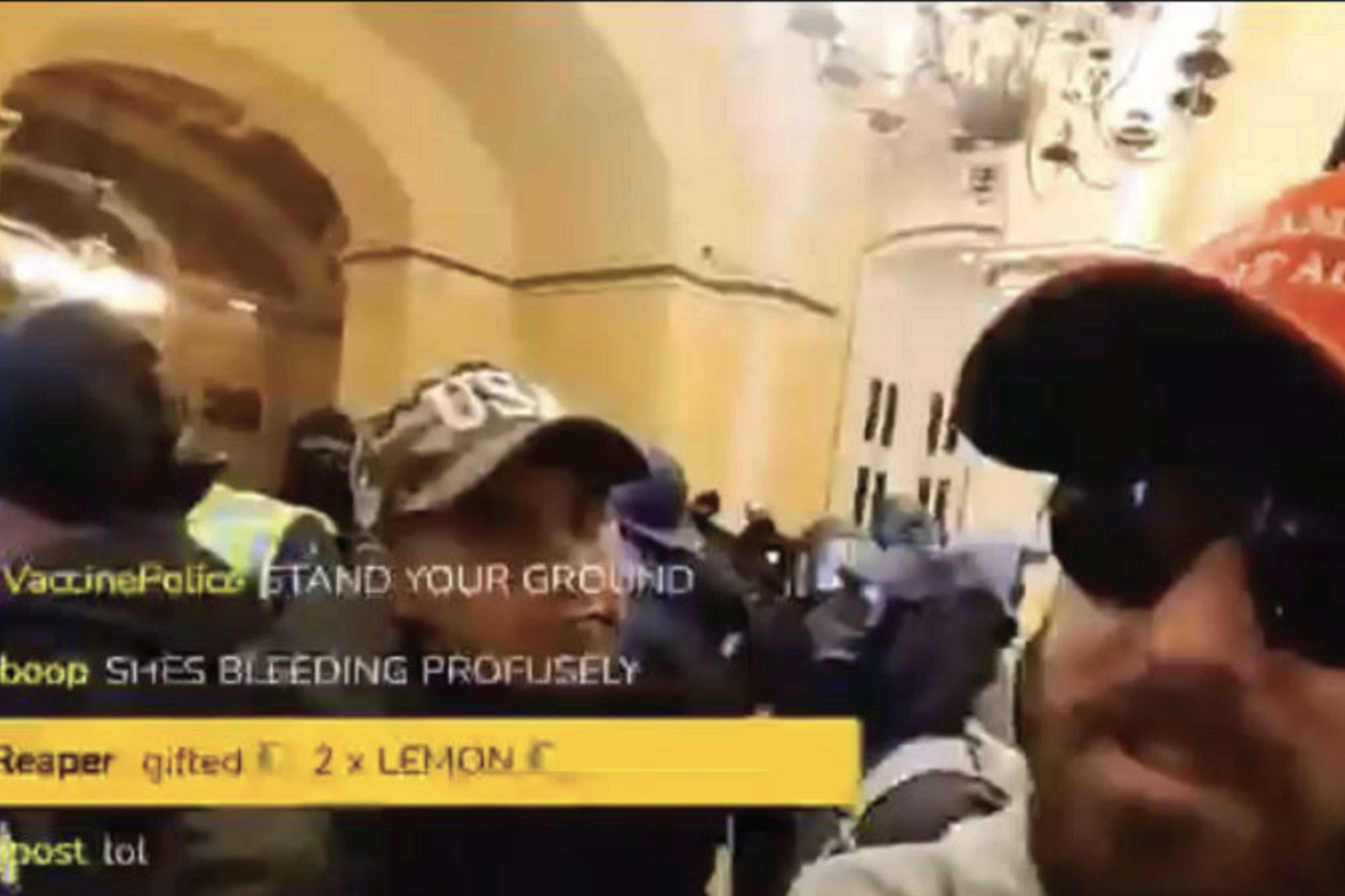 A man in sunglasses and a red hat is in a crowded room with people wearing hats and masks. There's a live chat overlay on the left.