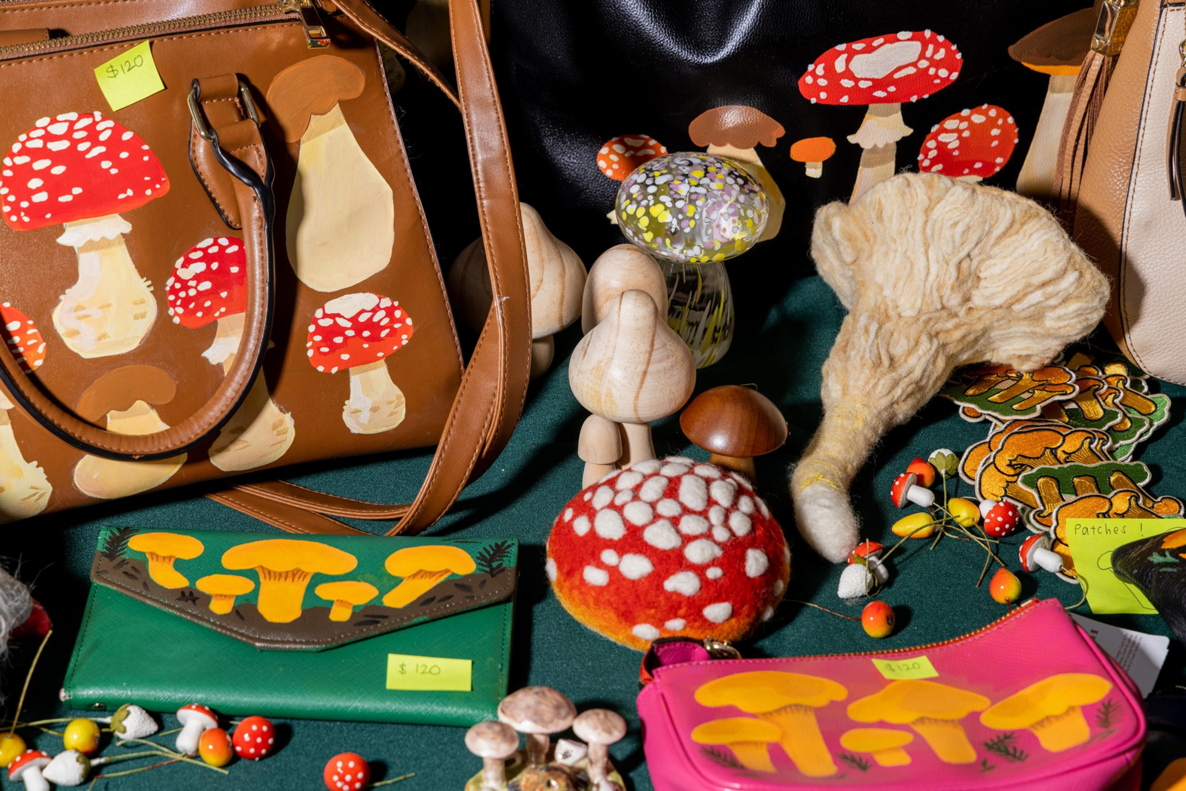 The image features various mushroom-themed items, including bags, purses, and decorative objects with mushroom patterns and designs displayed on a green surface.