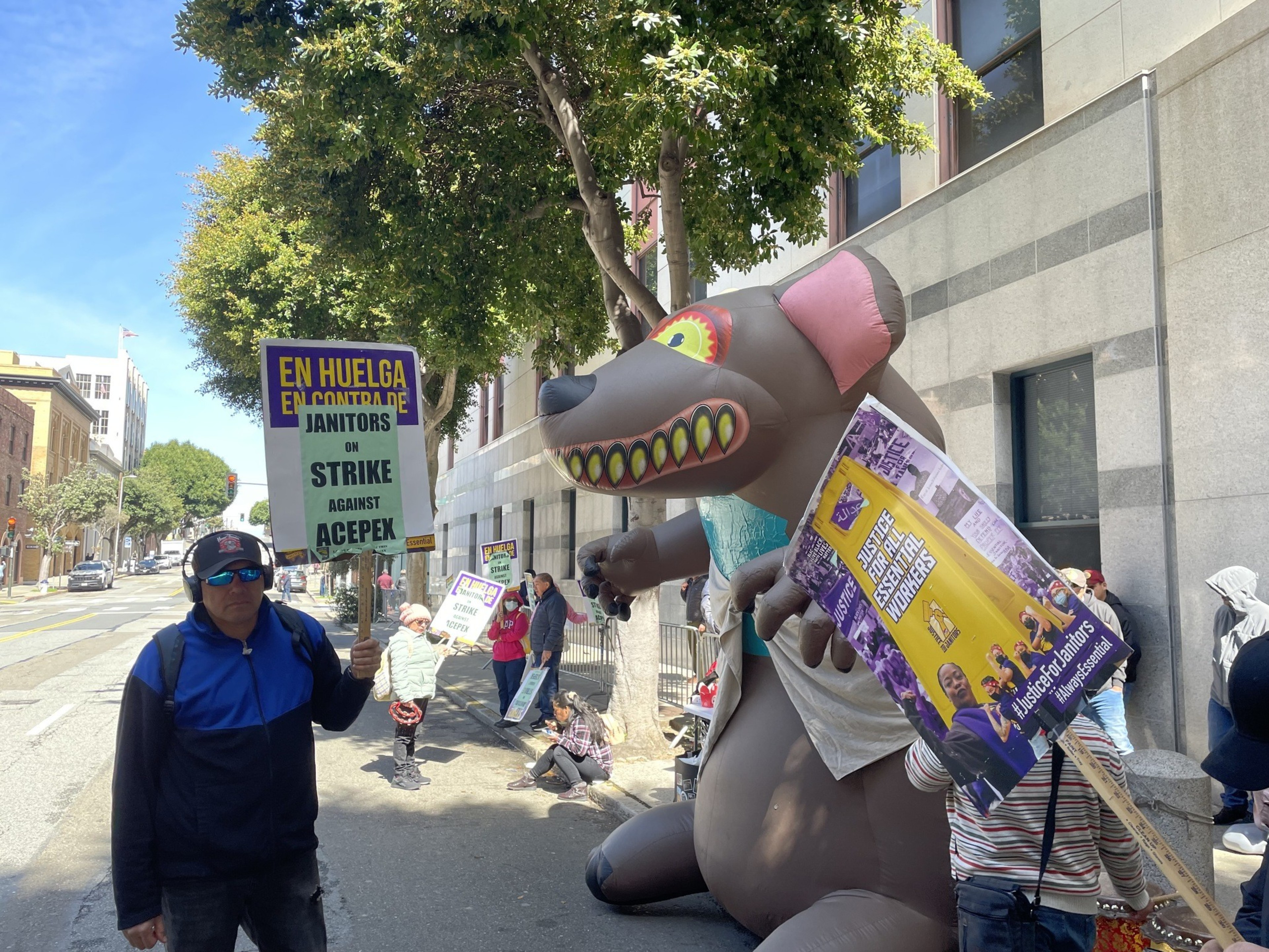 Union picketers line up outside a government office building.