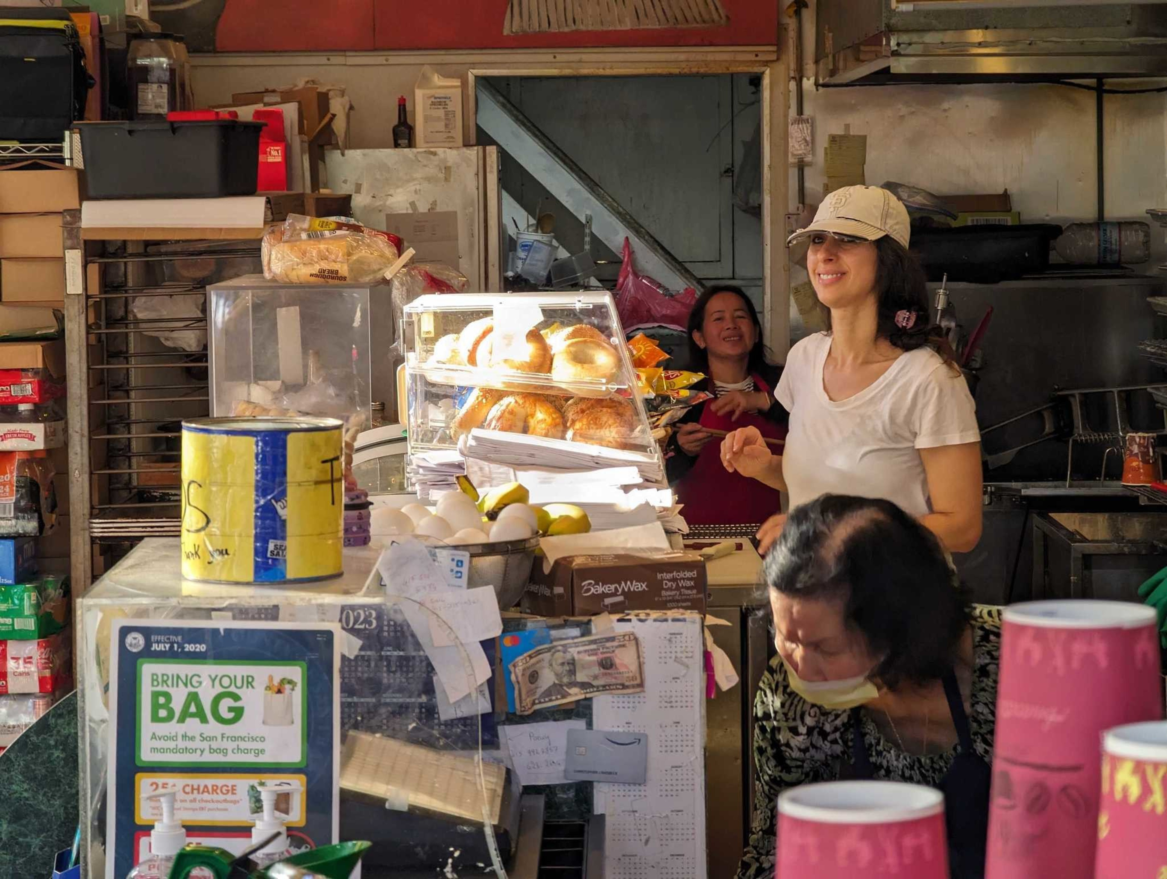 Workers behind the counter at Happy Donuts greet customers Wednesday.