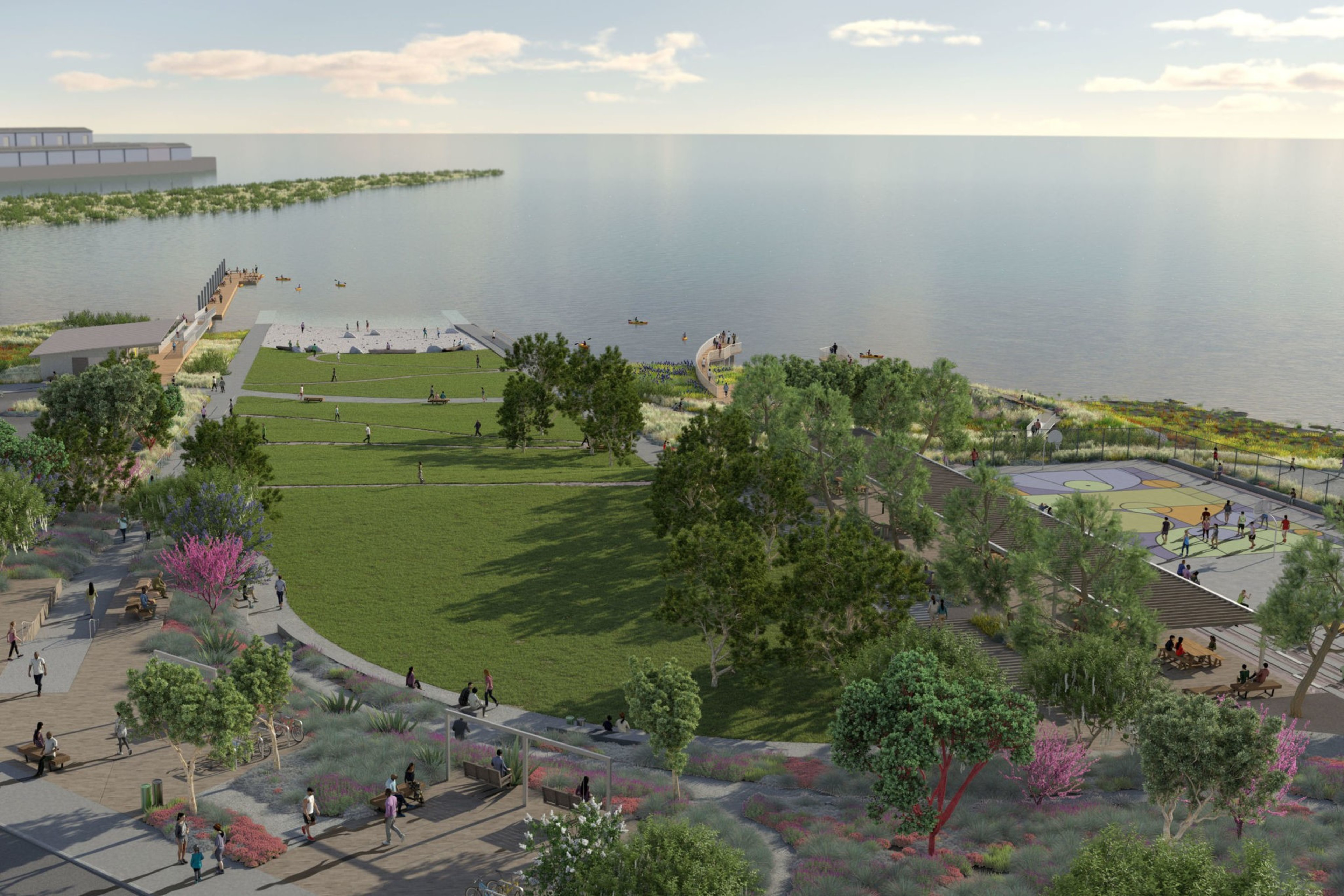 A coastal park with green lawns, walking paths, a basketball court, trees, and people enjoying the waterfront near a pier and calm water.