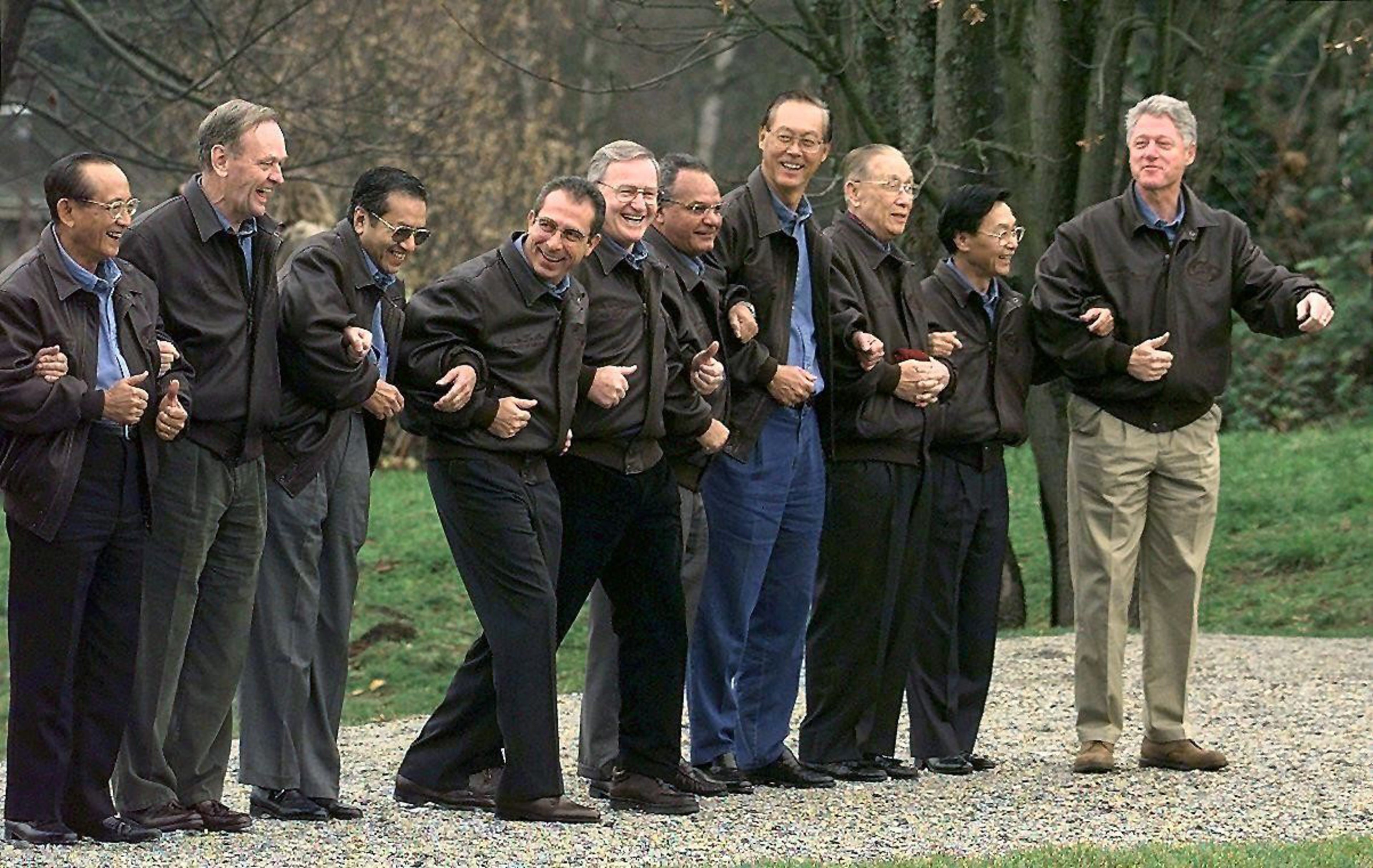 World leaders in matching dark jackets pose arm-in-arm for a Vancouver photo.