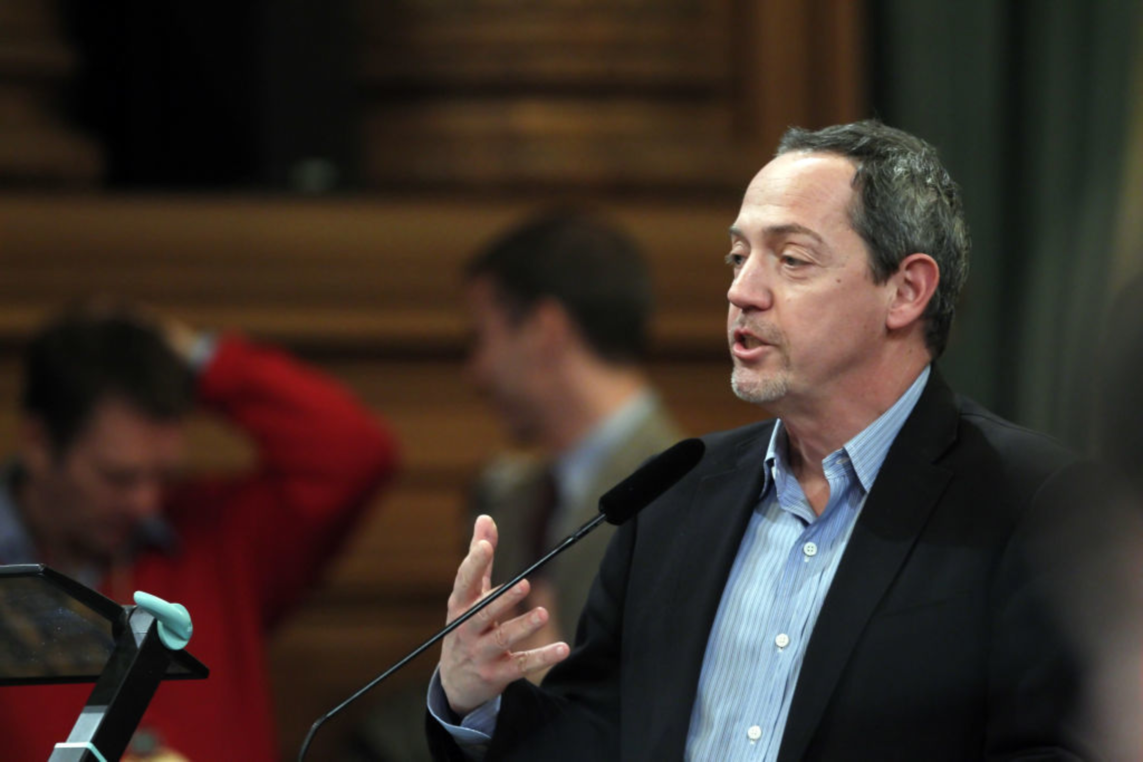 A man stands at a lectern.