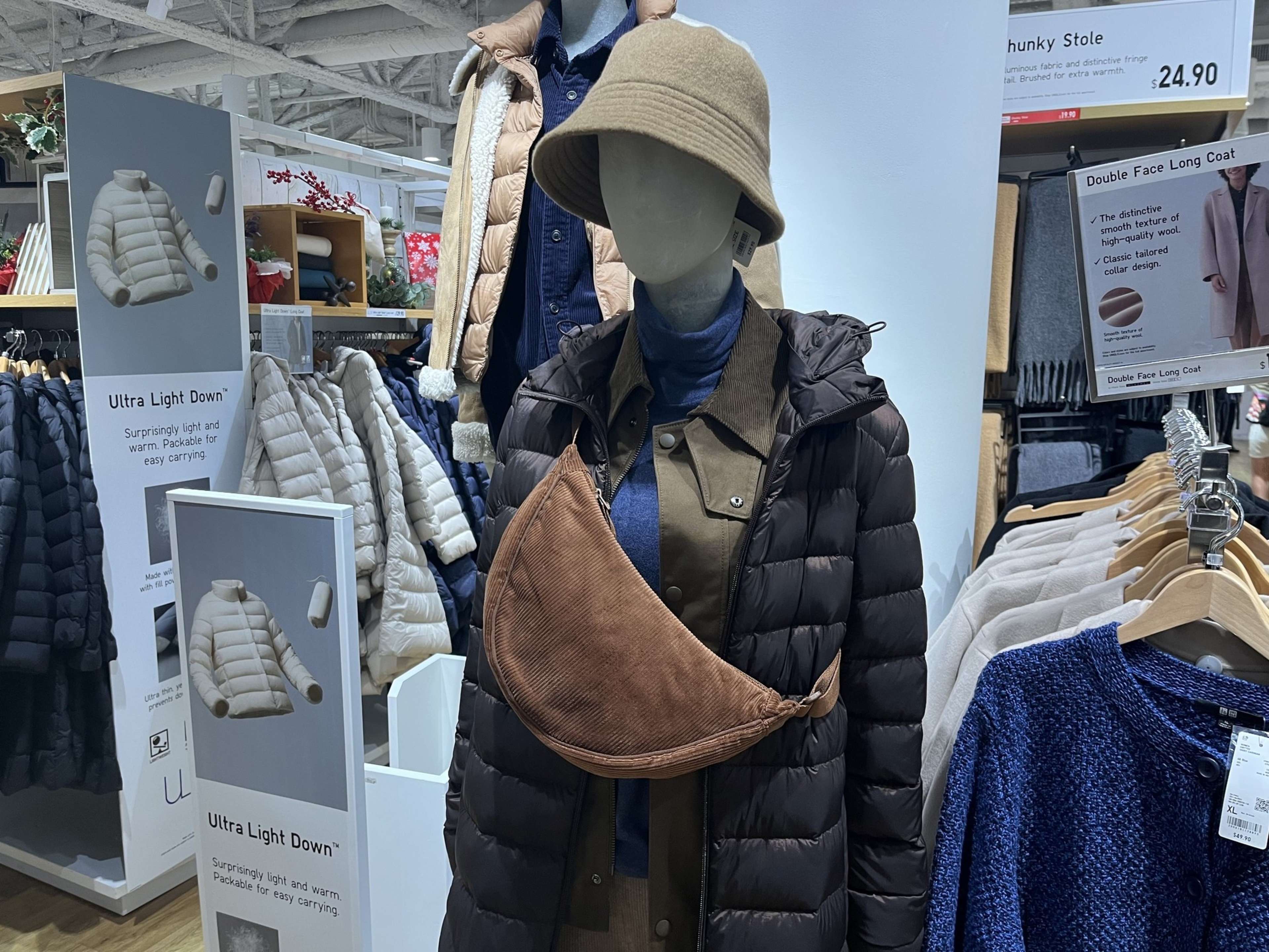 A mannequin wears a brown crossbody bag