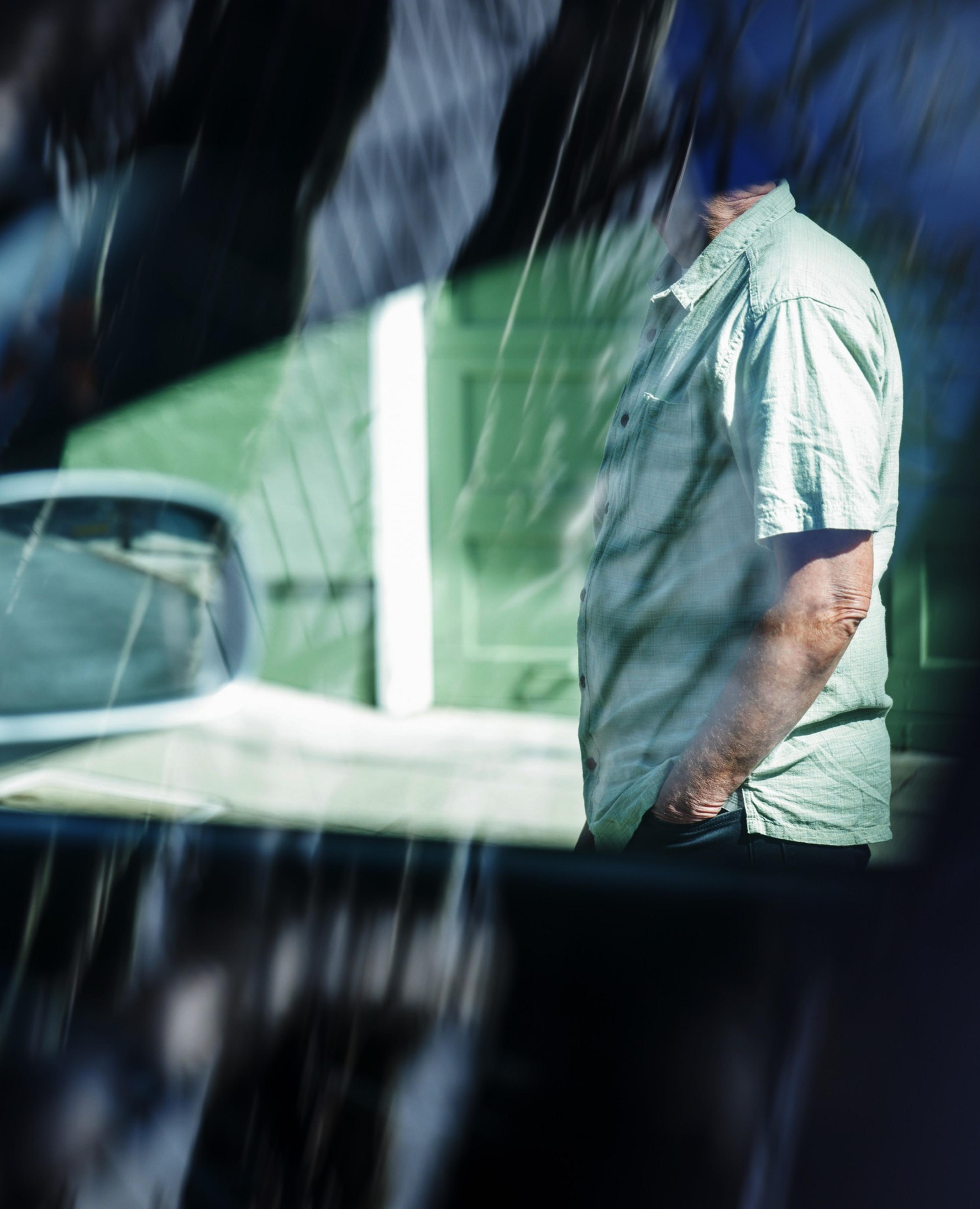 A man stands next to a car.