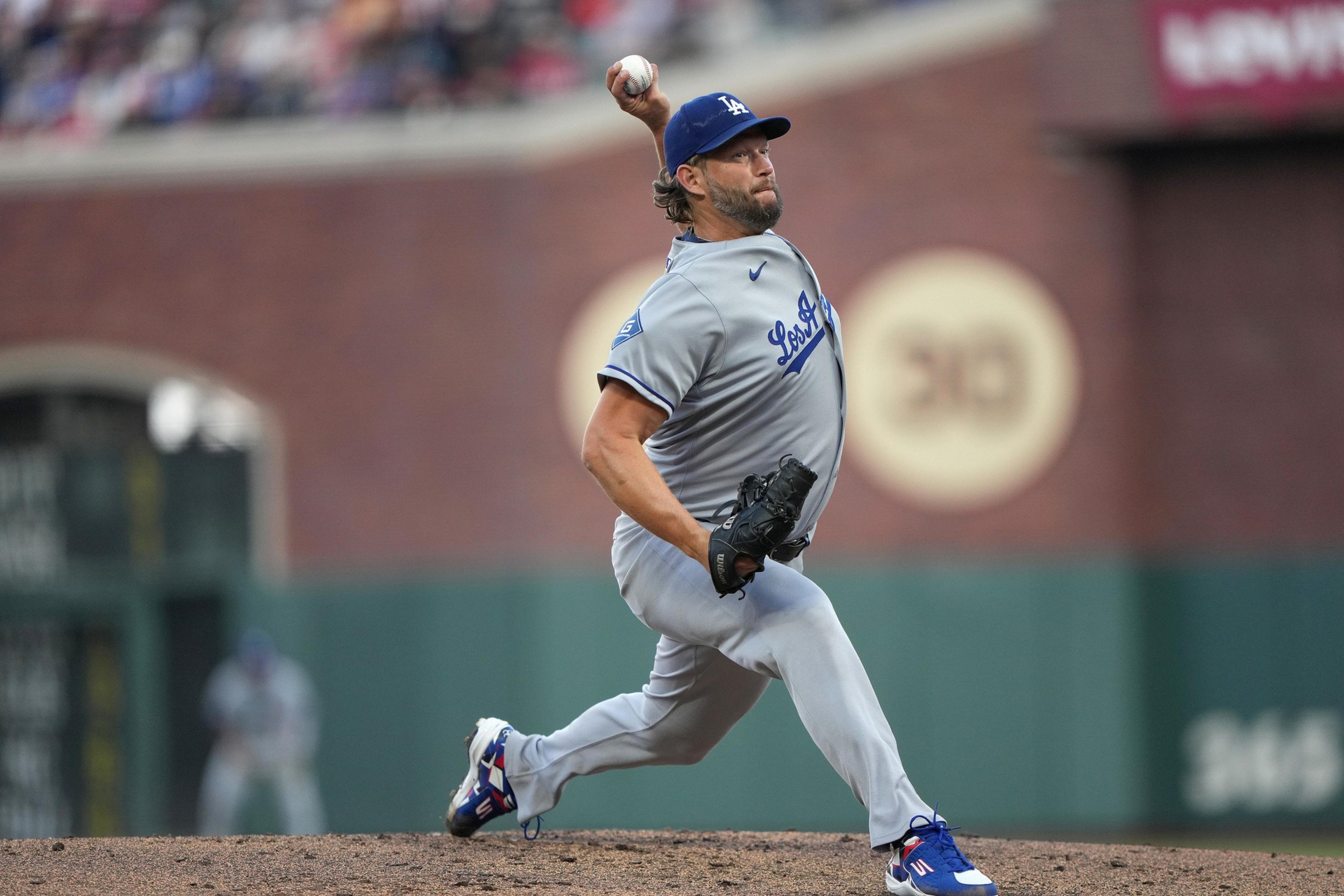 A baseball pitcher in a gray Los Angeles Dodgers uniform is mid-throw on the mound during a game.