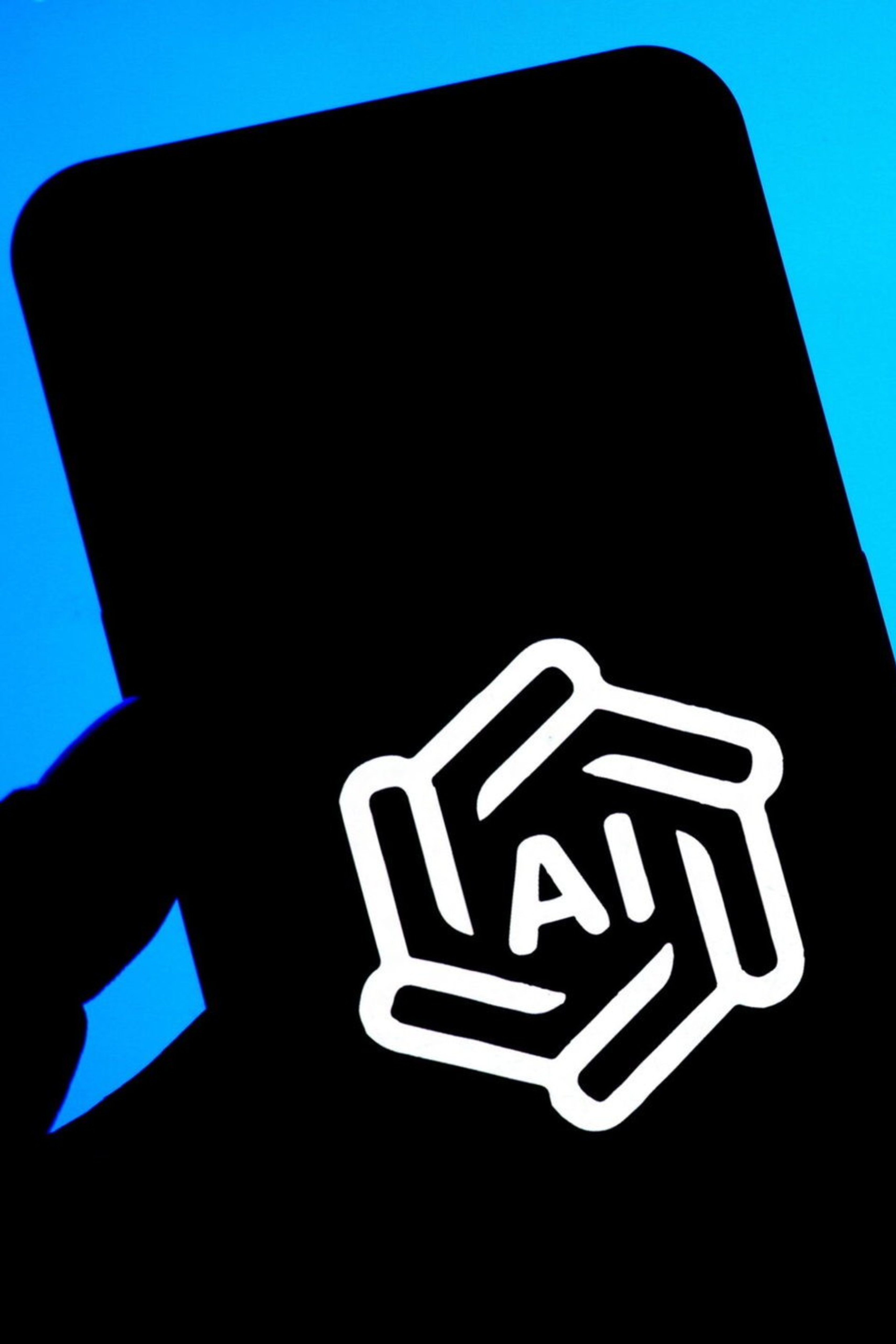 A smartphone screen displays the white OpenAI logo with "AI" inside, against a blue background showing the full OpenAI logo and partial text.