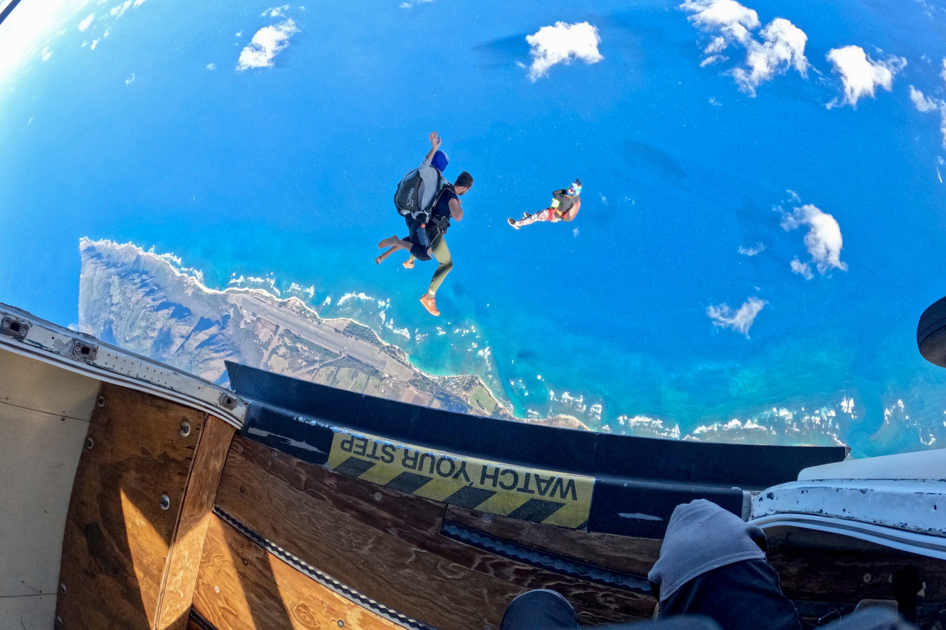 A person flying through the air after jumping out of a plane. 