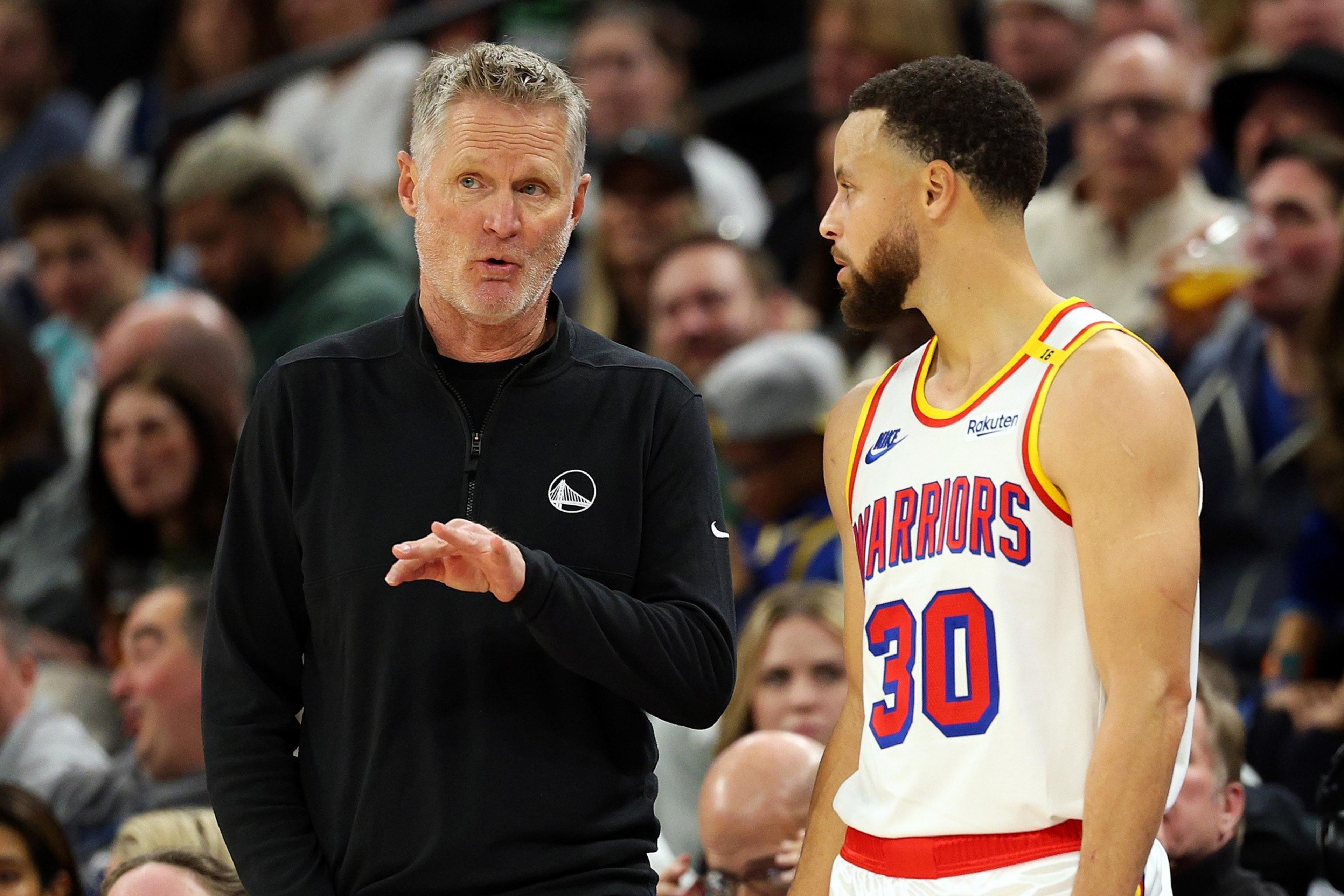 A man talking to another man on the basketball court