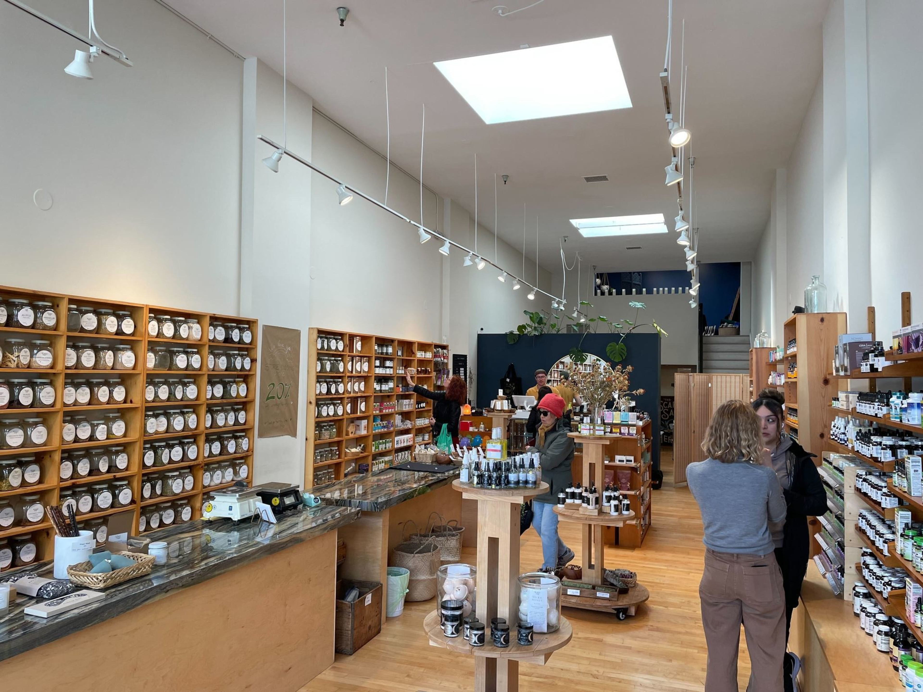 A shop contains shelves of dried tea leaves, vitamin supplements and other products.