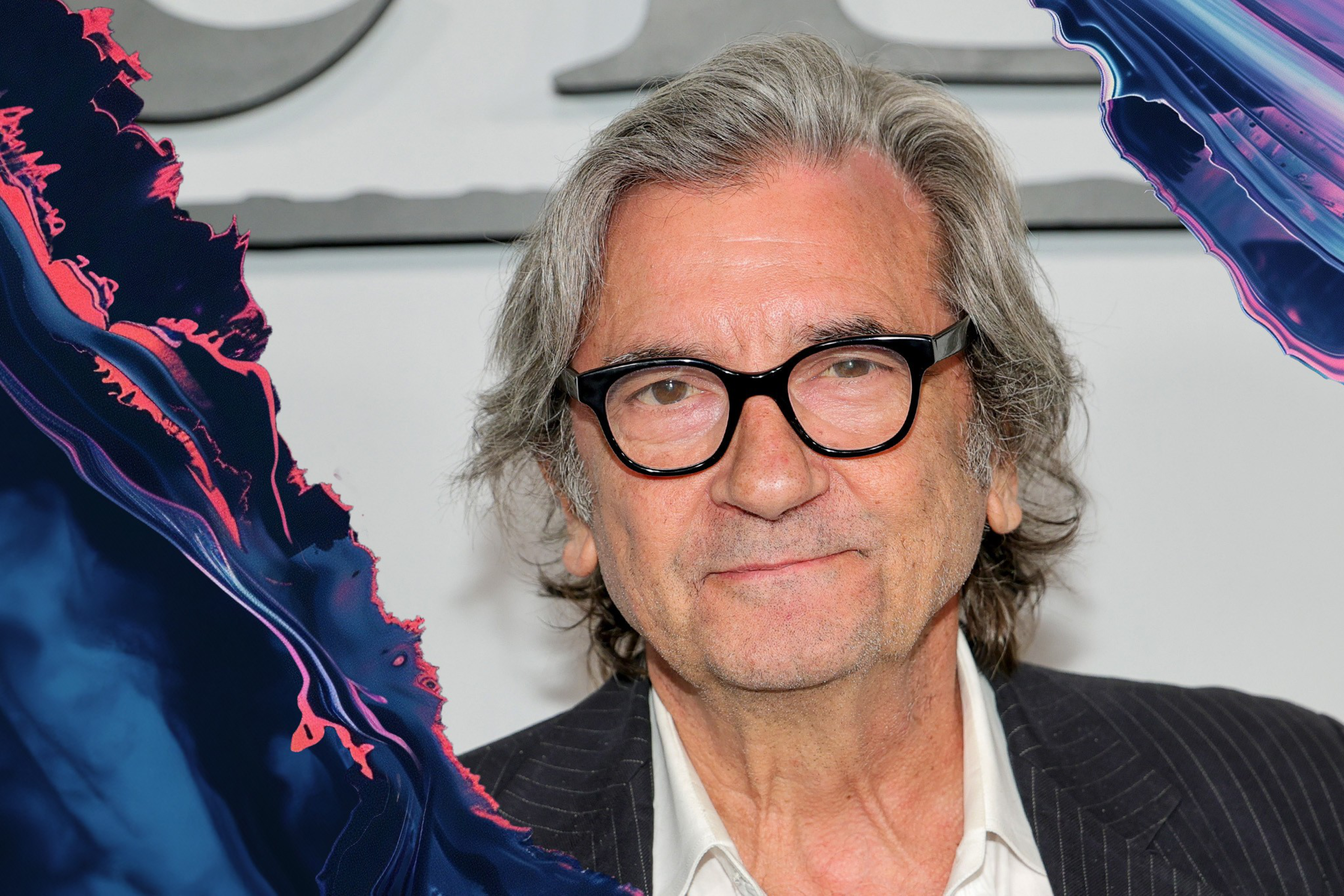 An older person with gray hair and glasses is smiling subtly. They are wearing a white shirt under a pinstripe jacket. The left side has a colorful, abstract effect.