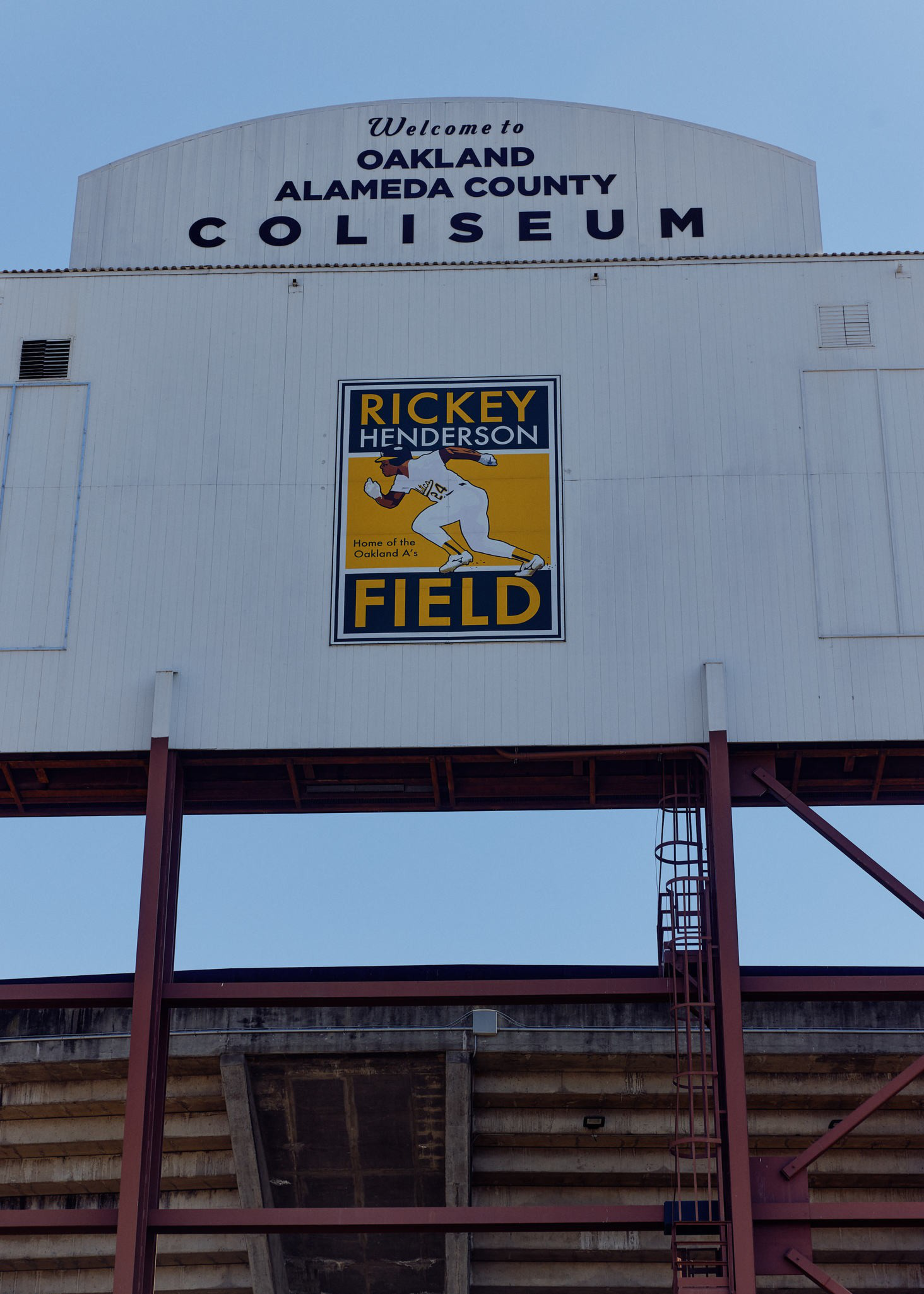 Welcome sign for Oakland Alameda County Coliseum featuring a Rickey Henderson Field logo with a baseball player illustration.