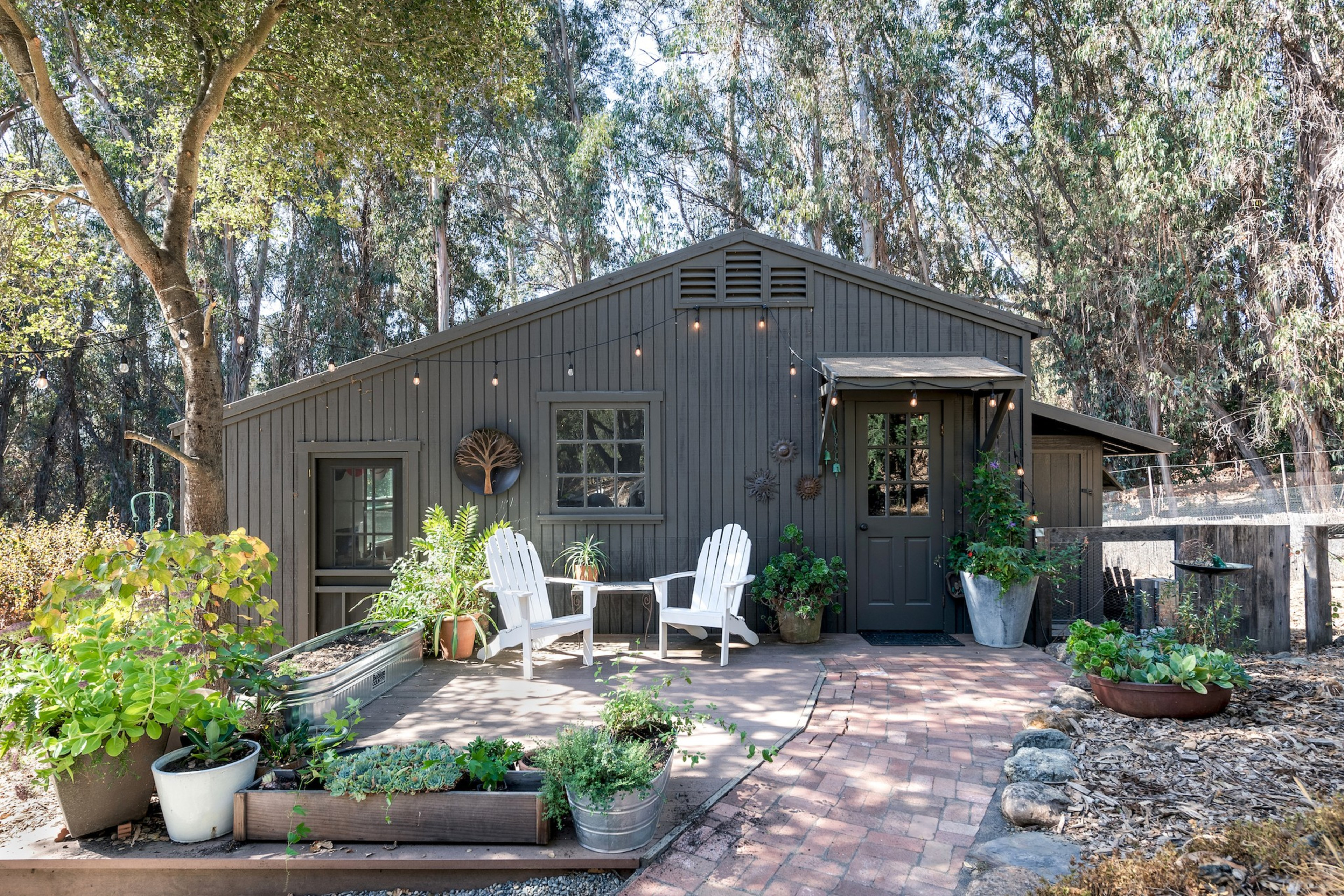 A gray house with patio furniture. 