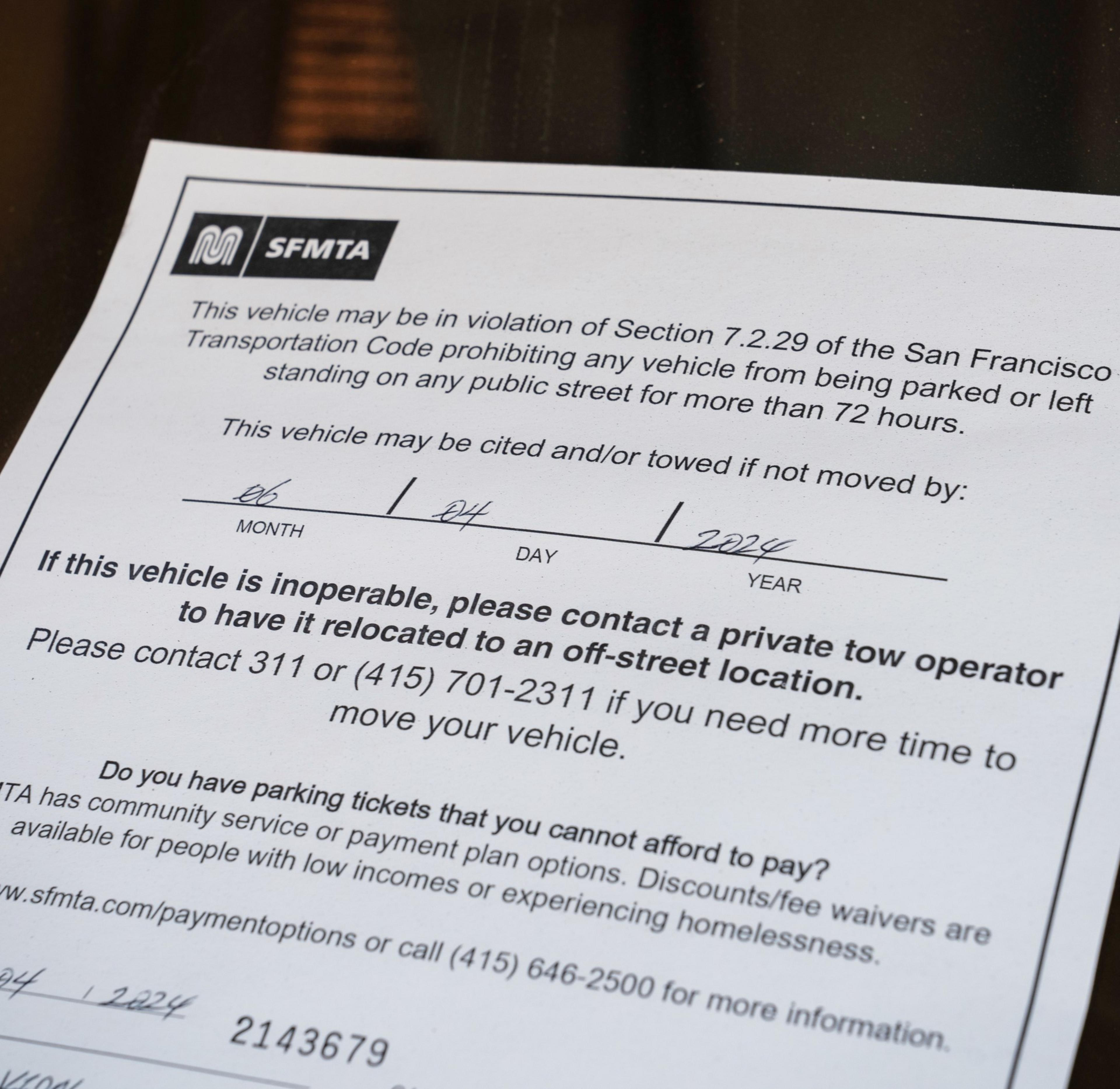 This image shows a notice from SFMTA stating that a vehicle may be towed for violating a parking regulation, with contact information provided for further assistance.