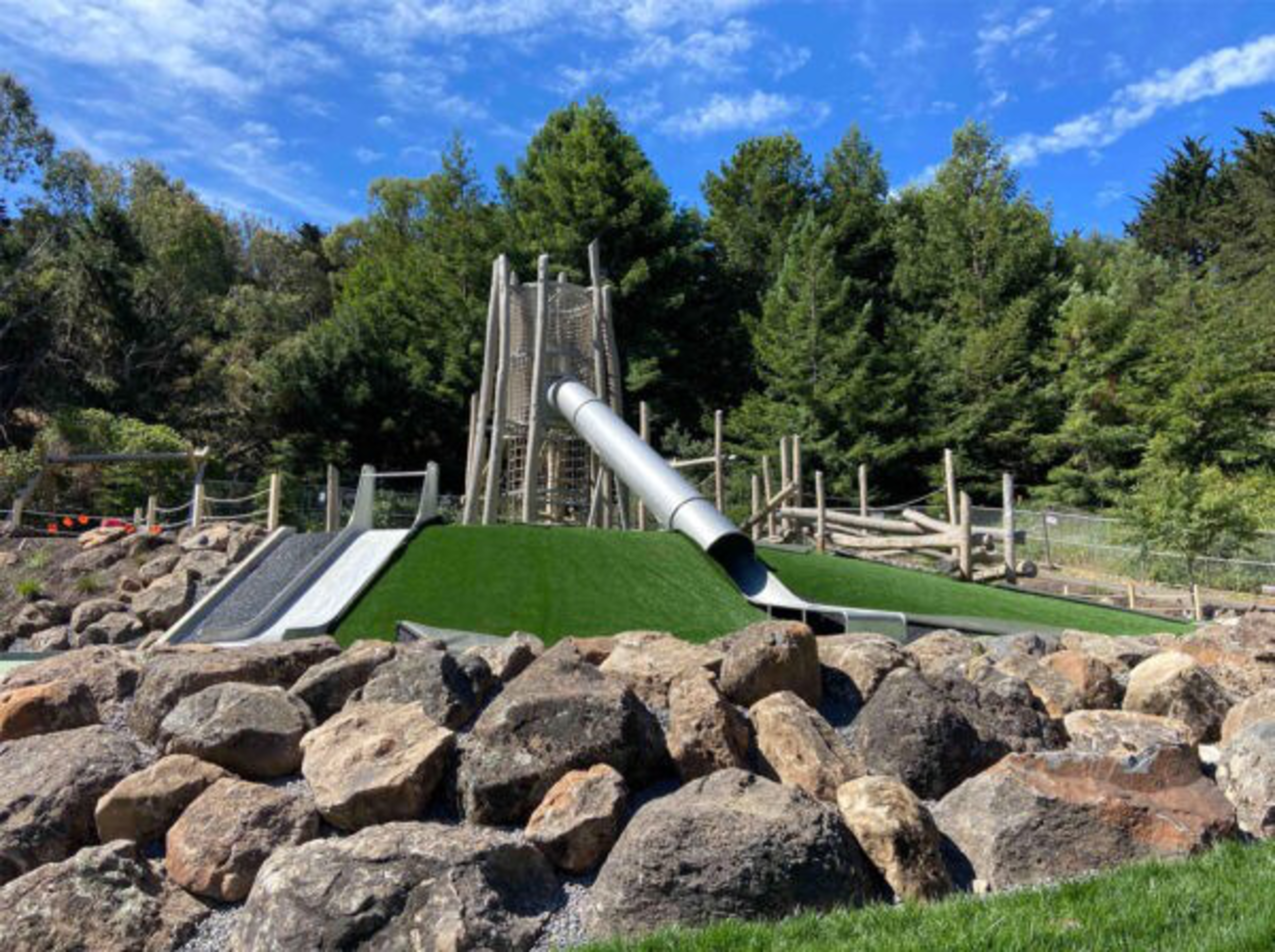 A slide with rocks in the foreground and a blue sky in the background.