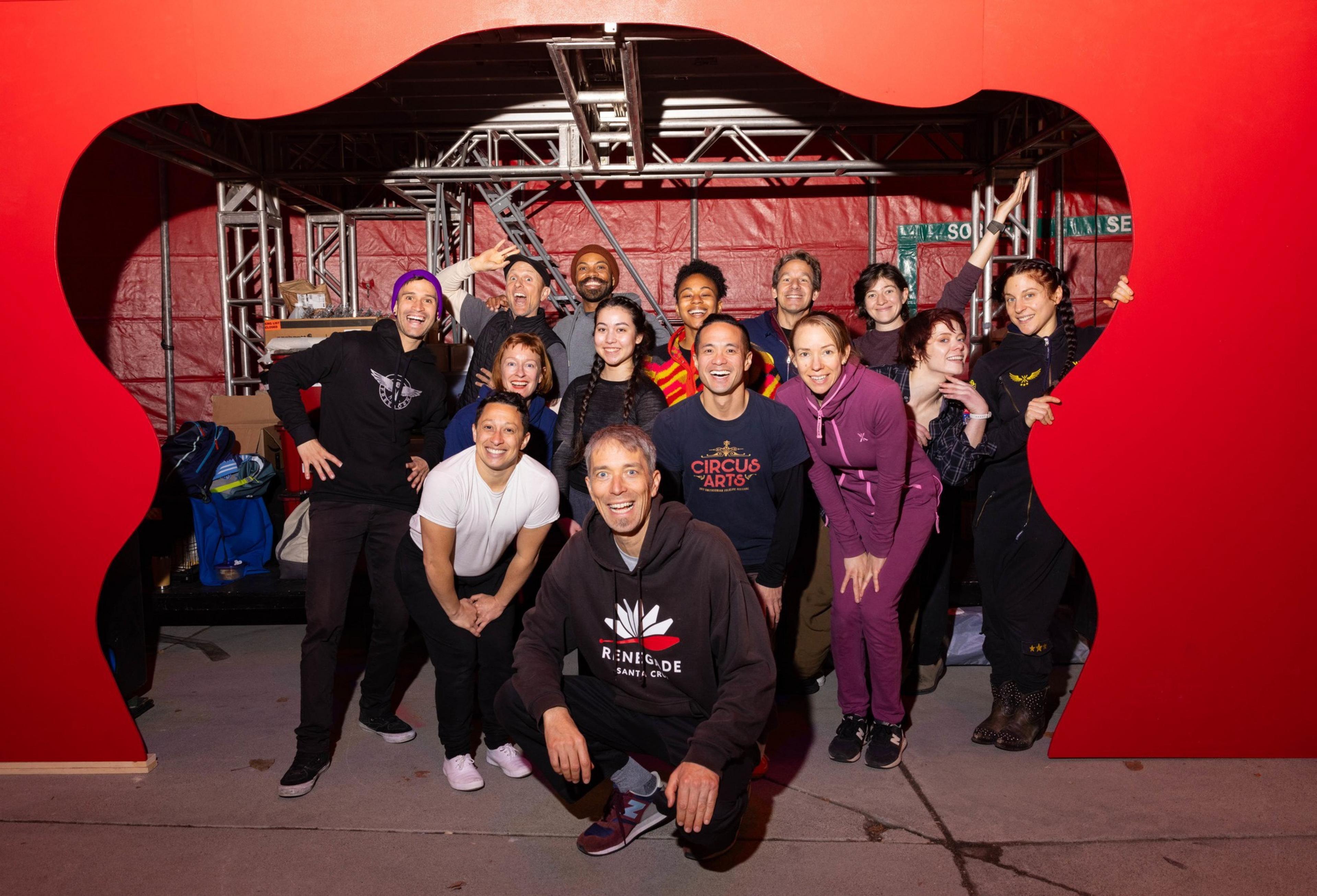A group photo of circus performers smile for the camera .