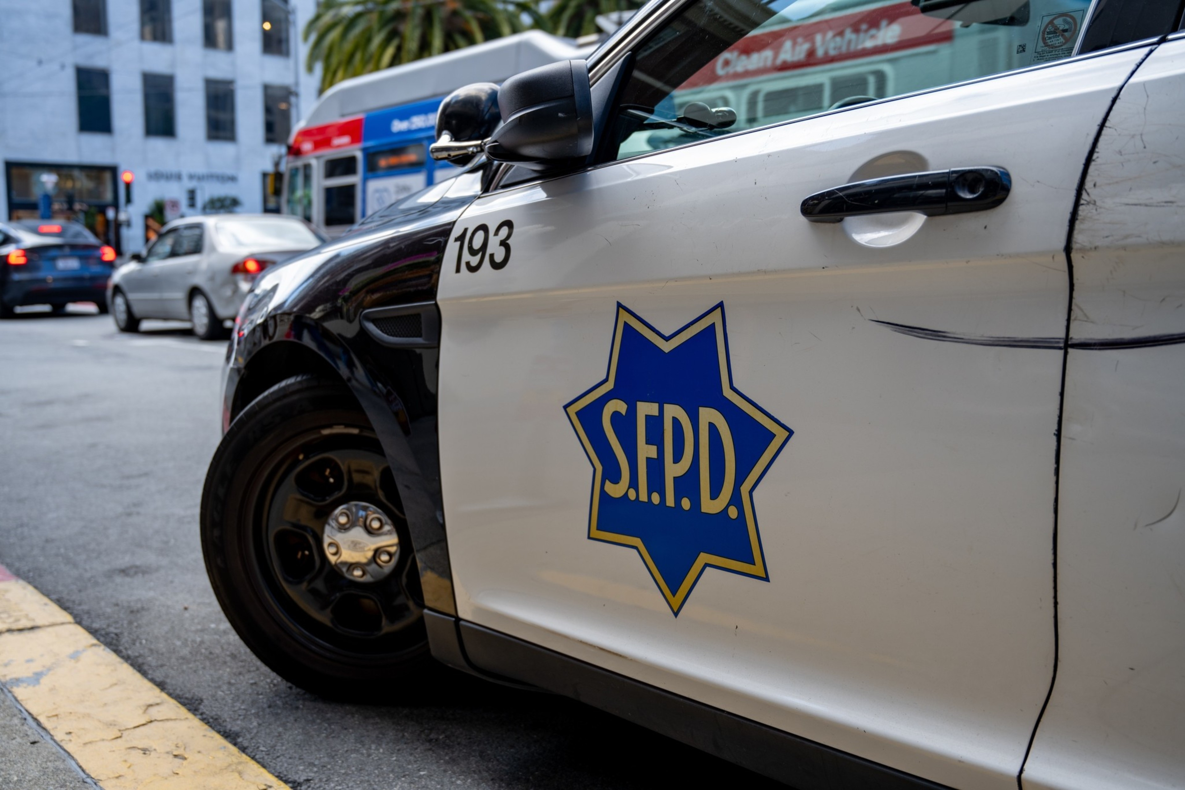 A white and black San Francisco Police Department car parked on a street with the S.F.P.D. emblem and number 193 on the door.