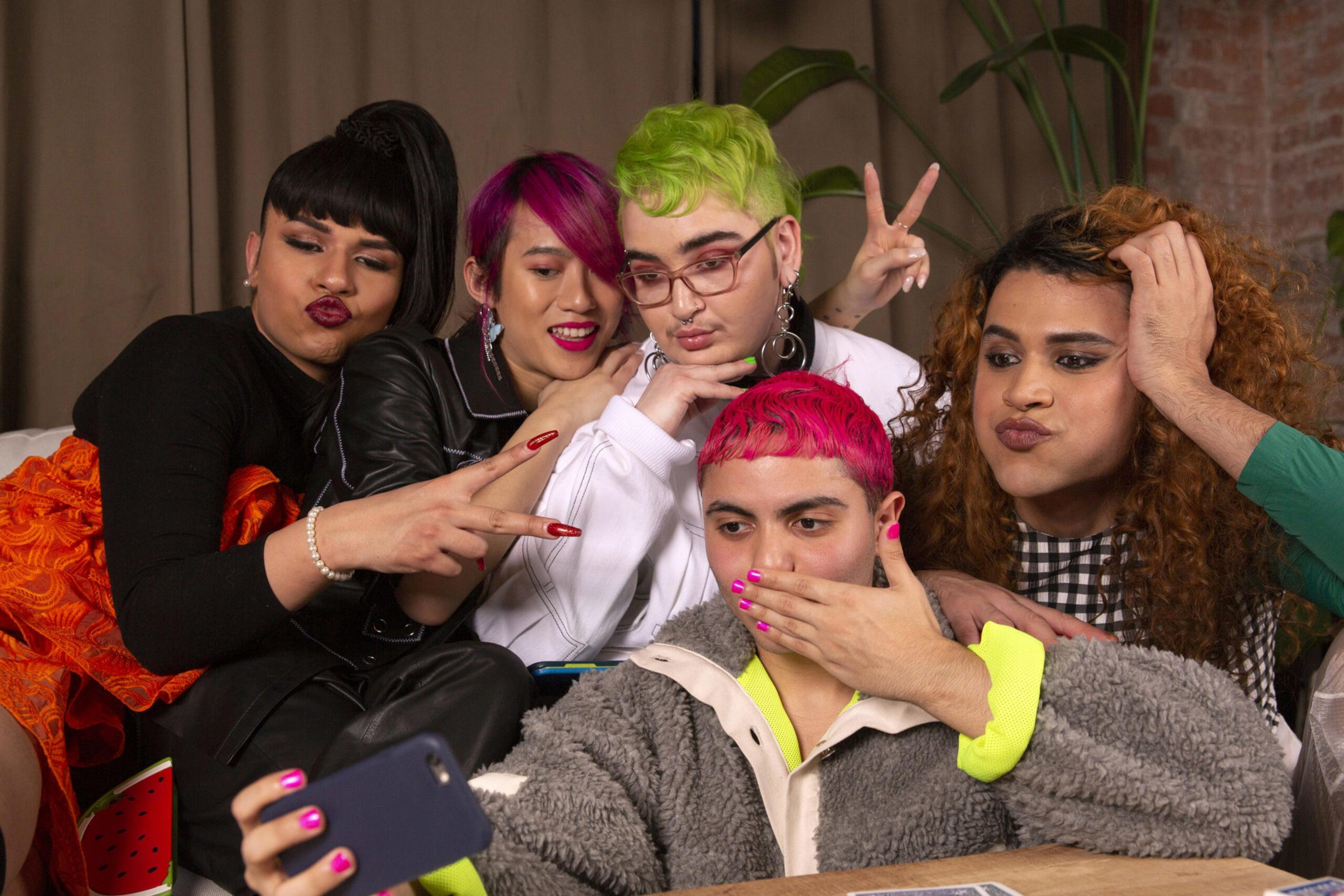 A group of friends of varying genders taking group selfie.