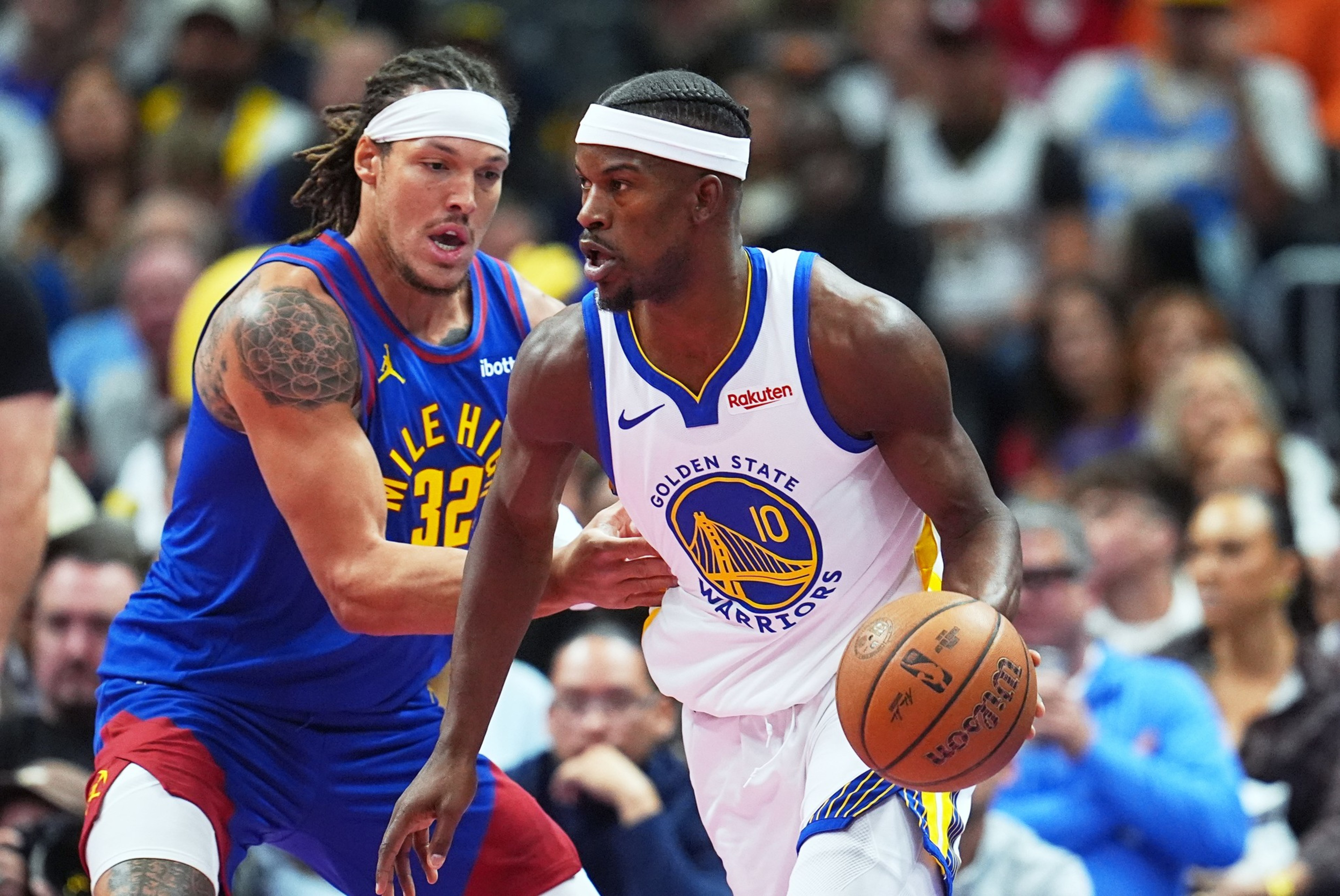 A Golden State Warriors player wearing number 10 dribbles the basketball while closely guarded by a Mile High player wearing number 32.