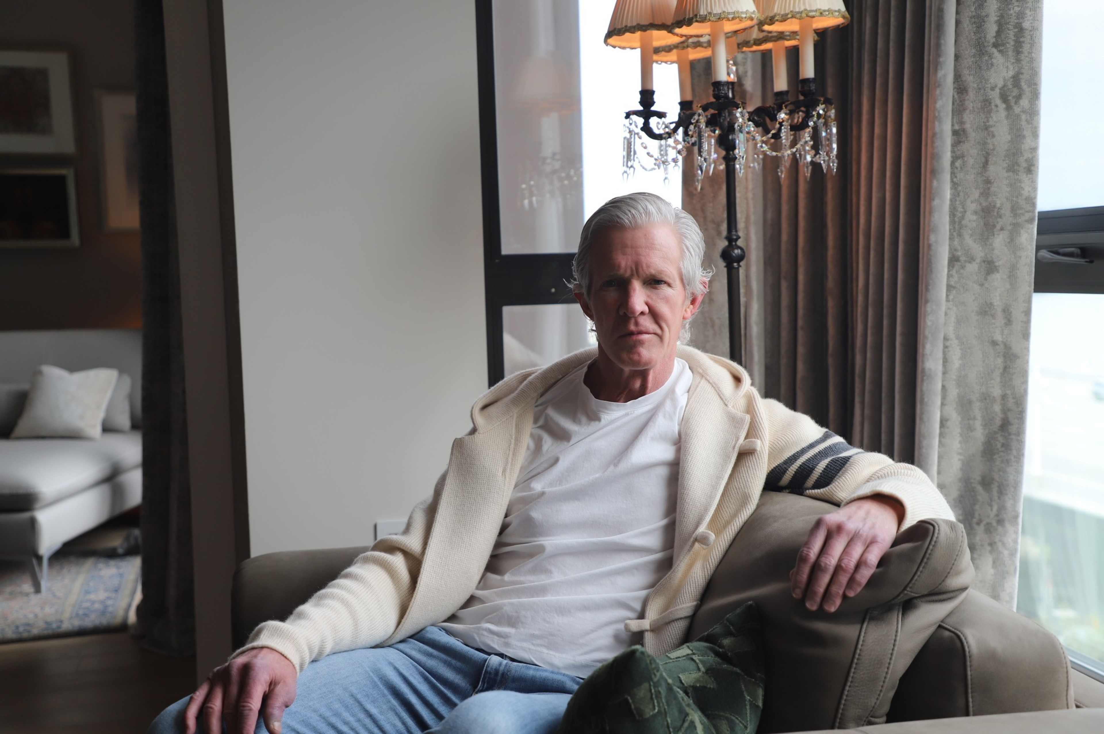 A man sits inside a fancy condo.
