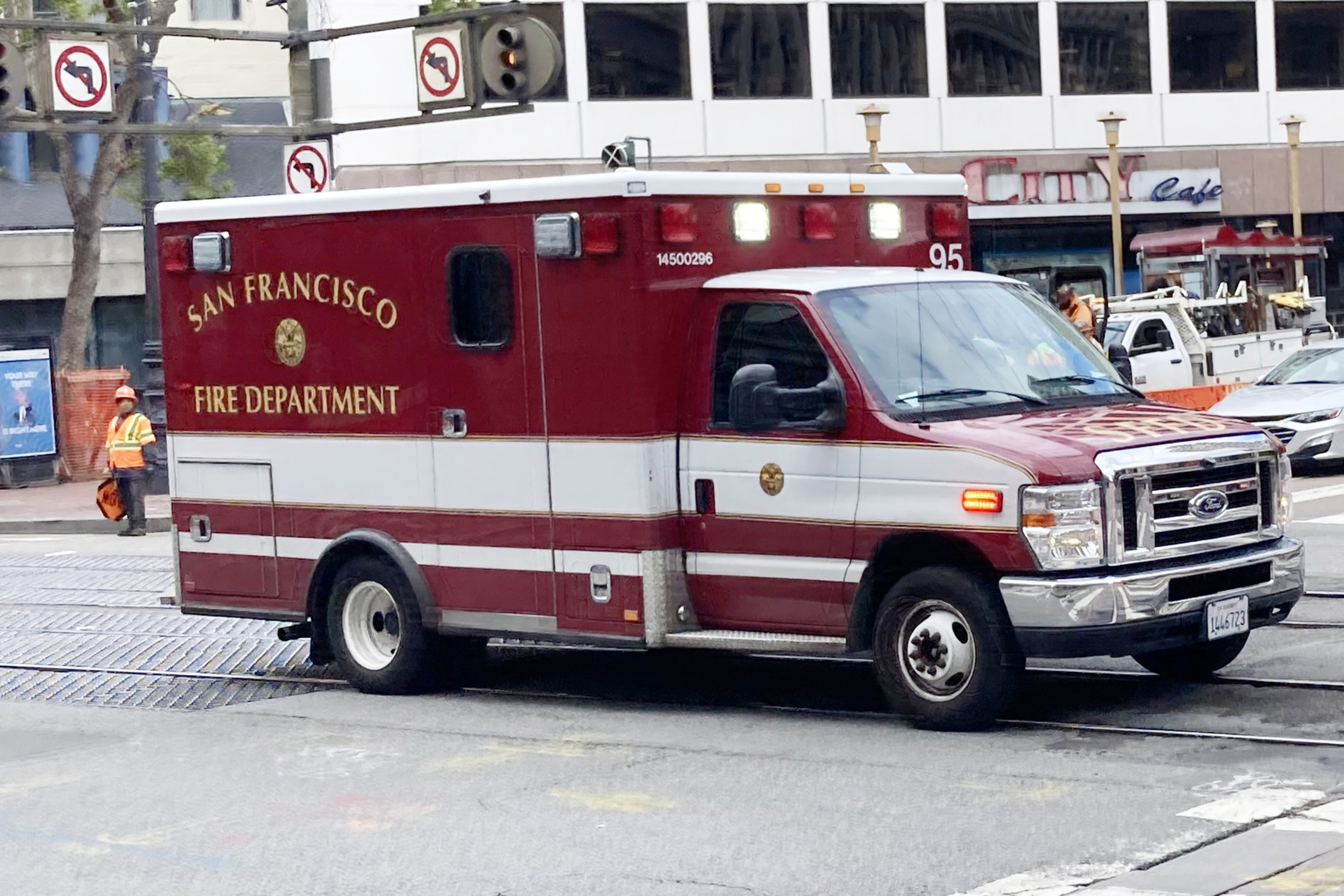 A San Francisco Fire Department ambulance is driving through an urban intersection.