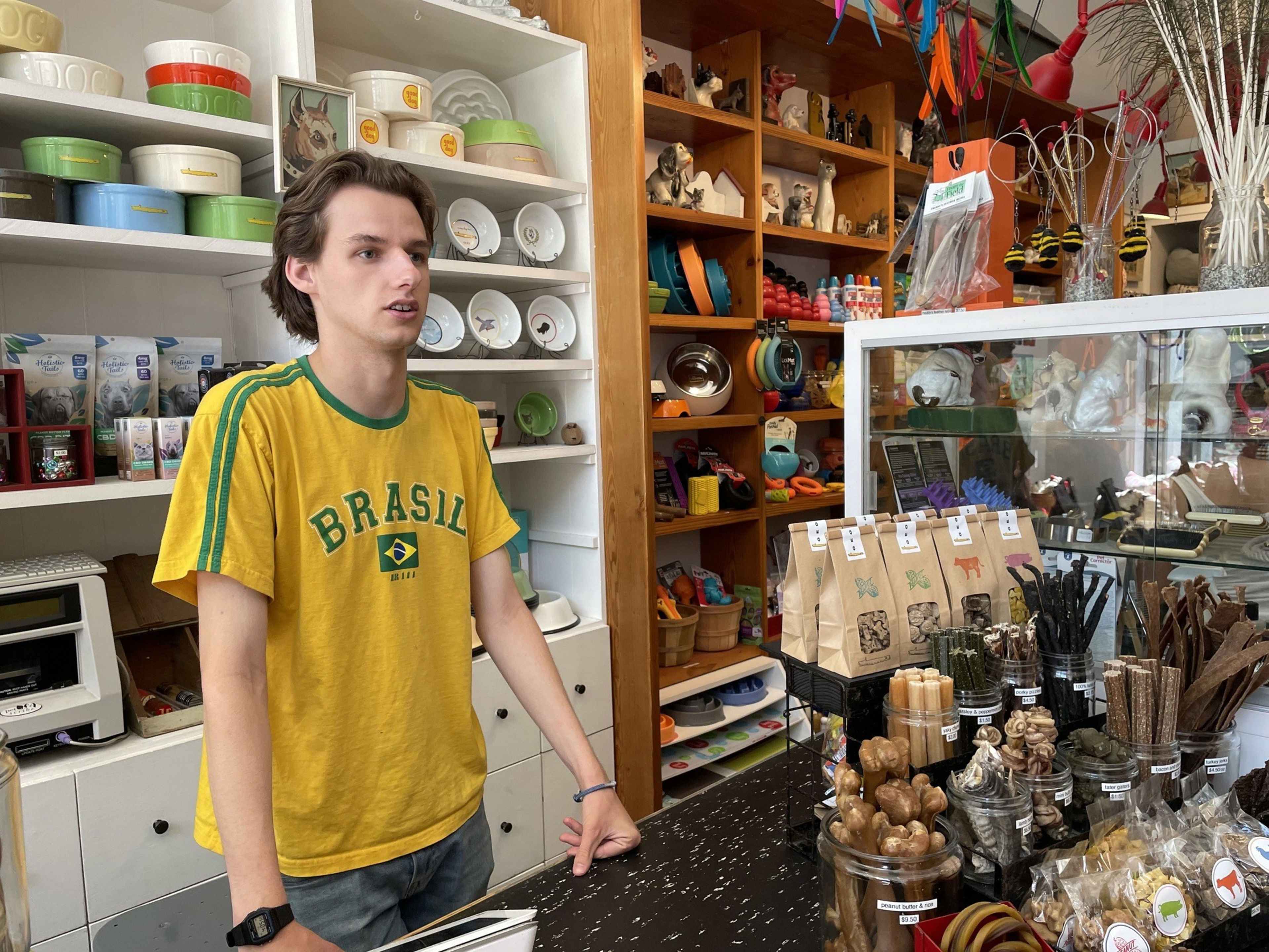 A cashier stands behind a counter inside a pet store.