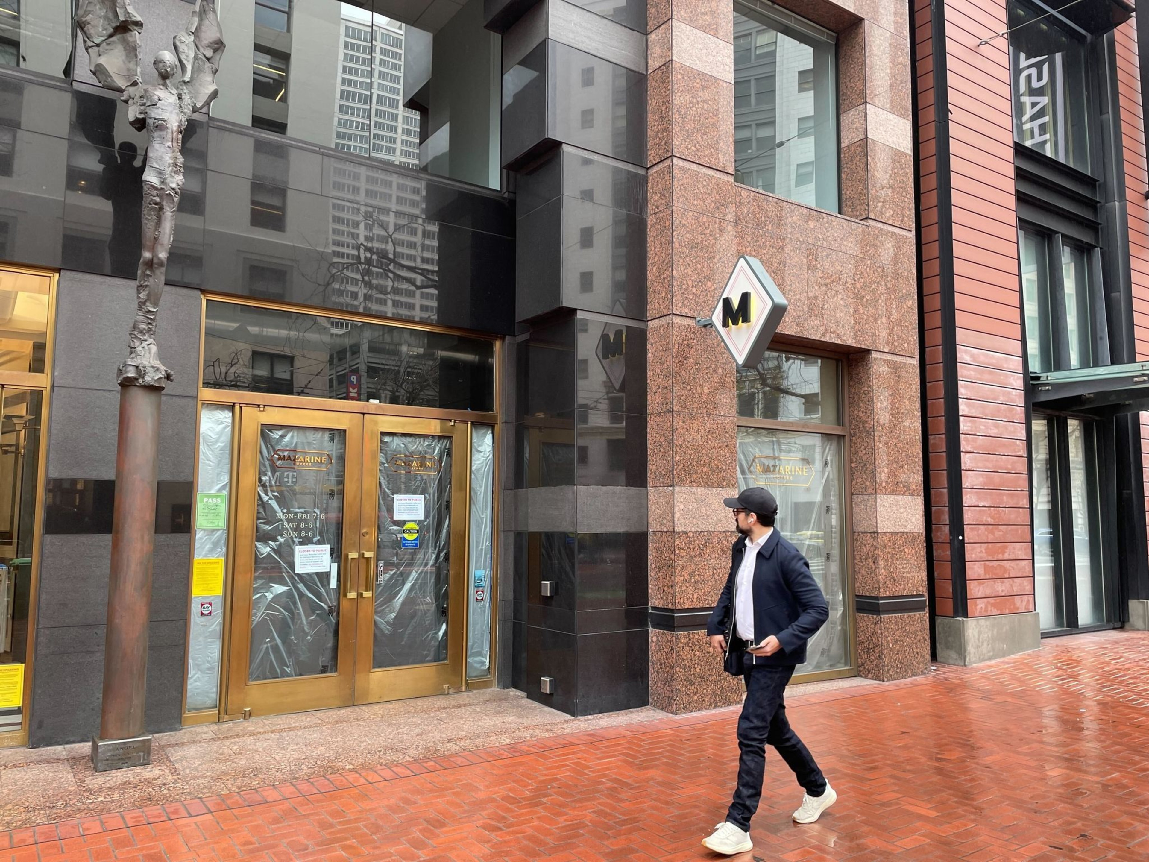 A person walks by a closed San Francisco cafe.