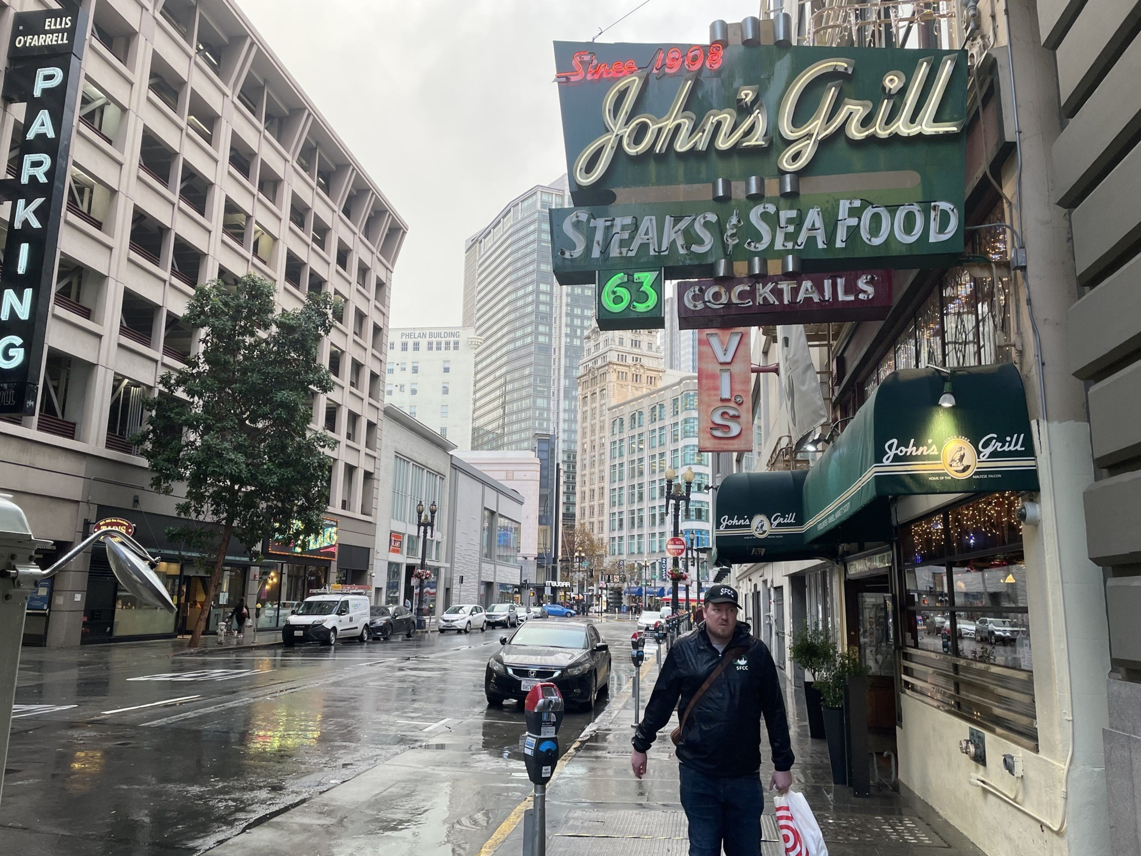 A man walks past a restaurant.