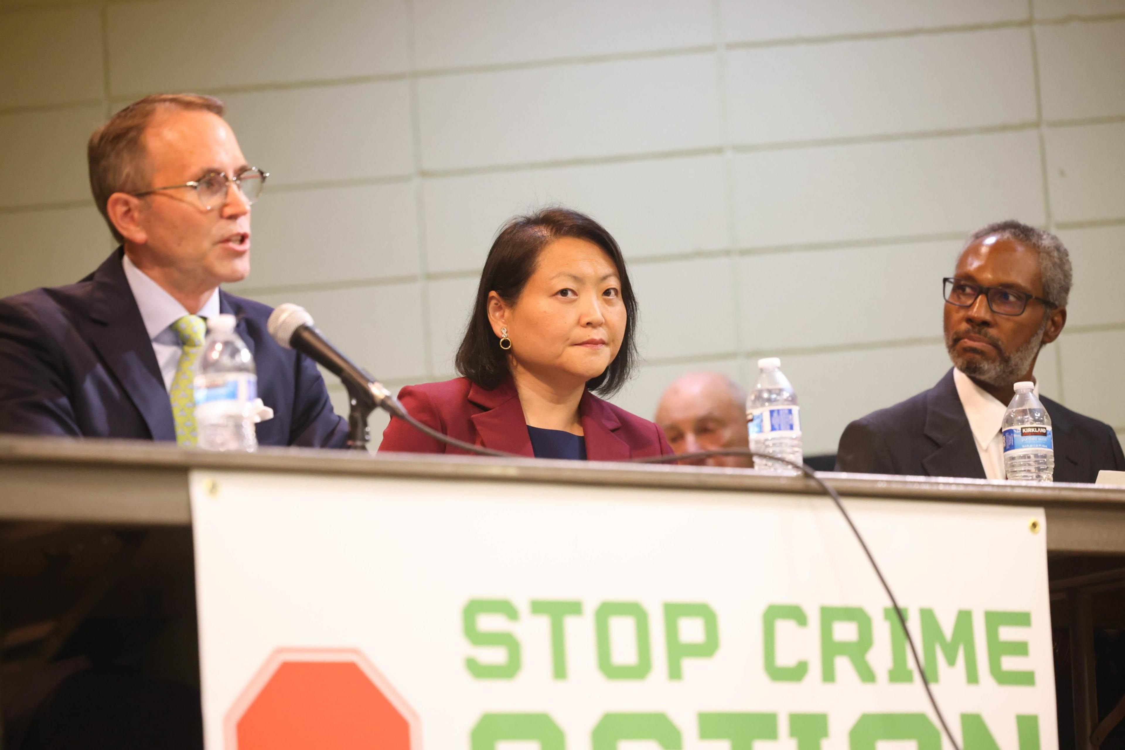 Two people sit at a debate table.