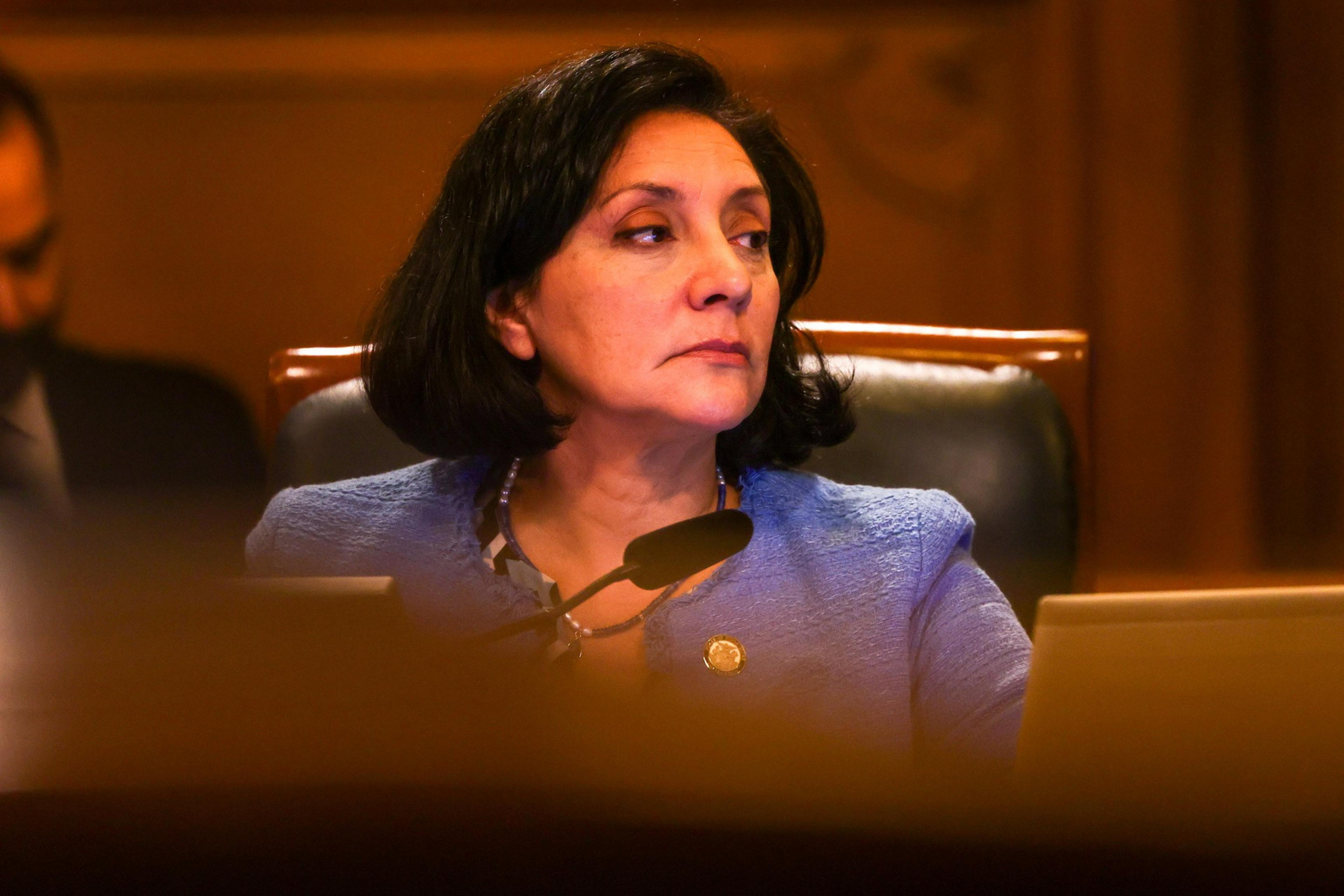 woman in purple suit sitting