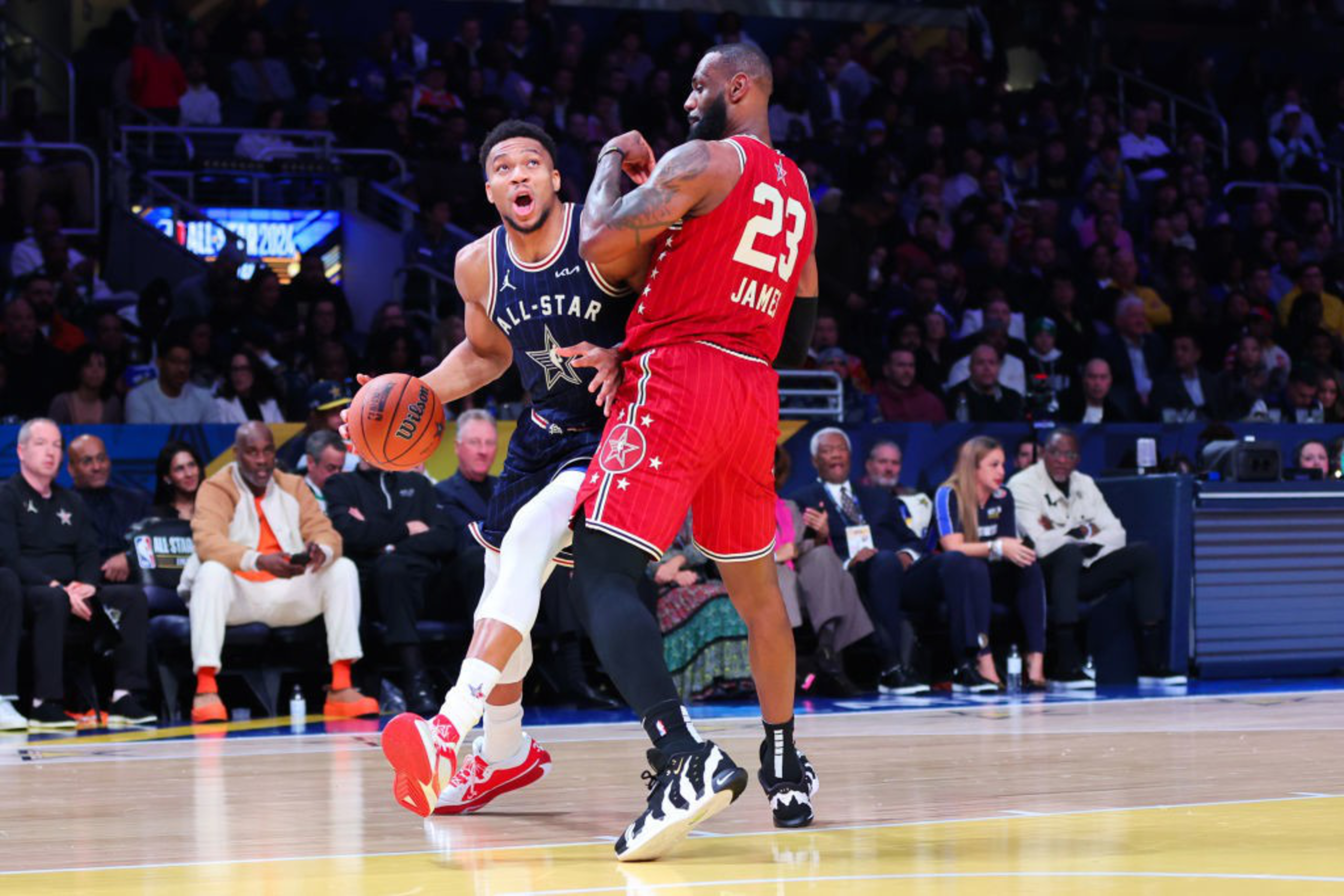Two basketball players play on a basketball court