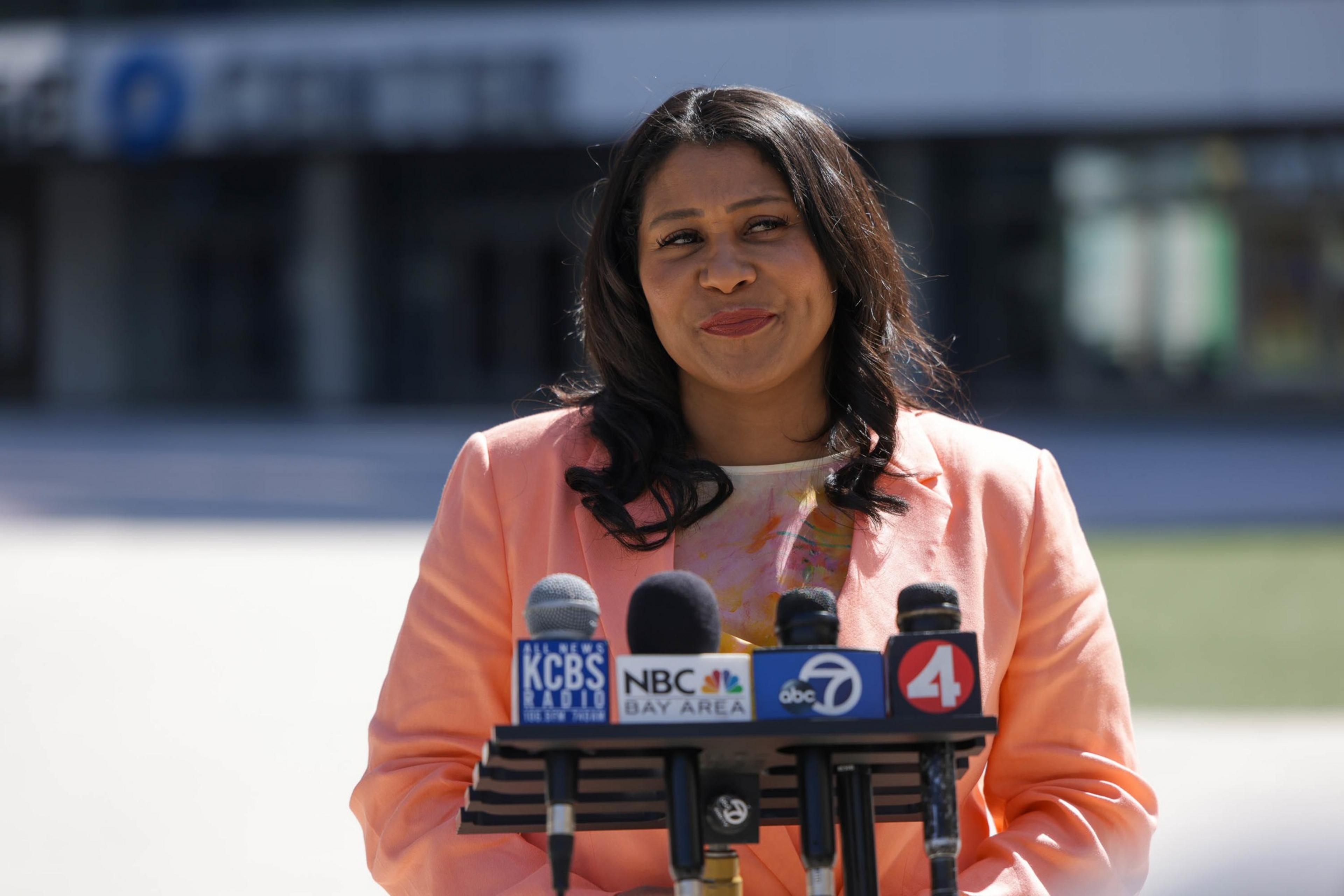 A woman stands at a mic. 