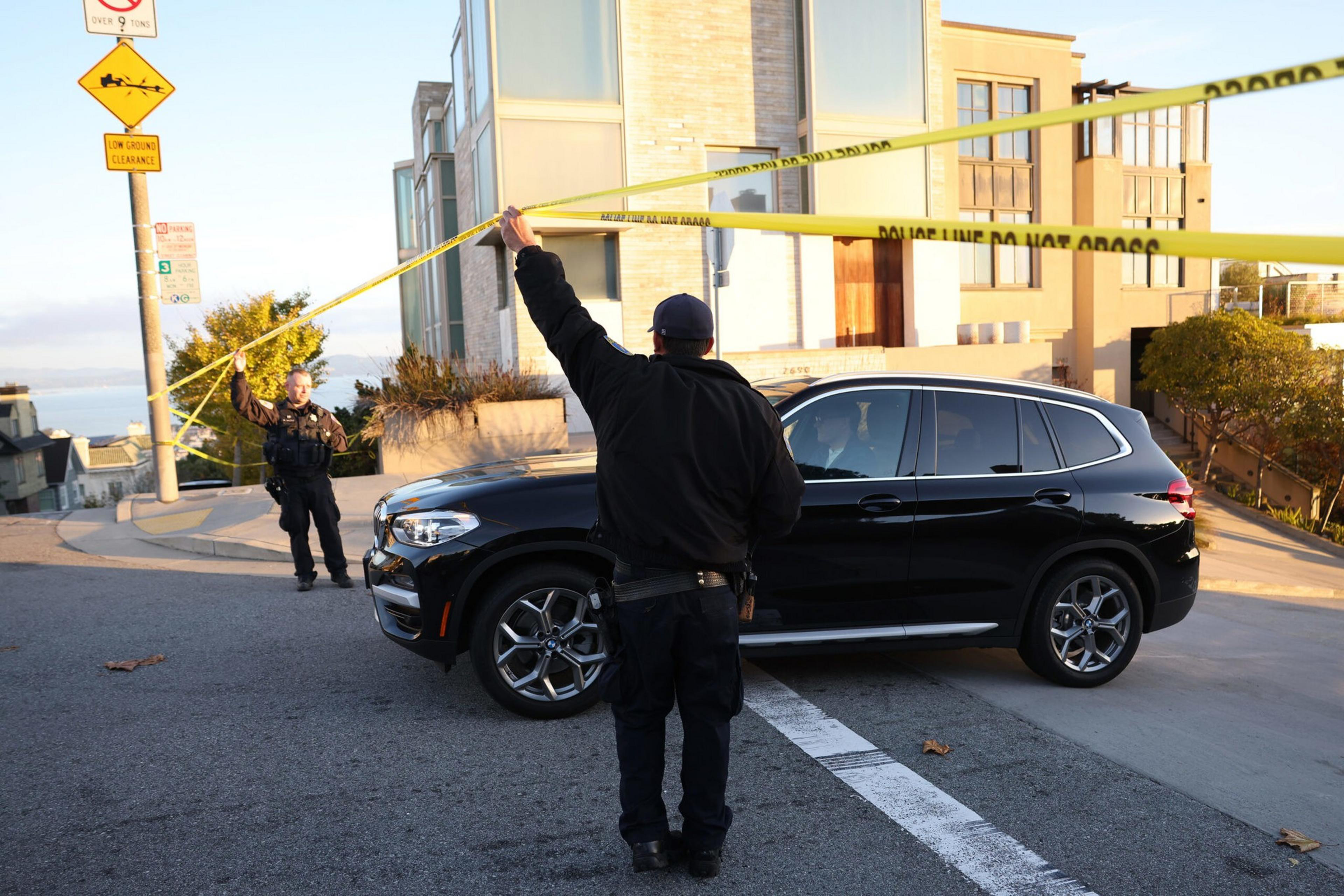 San Francisco police officers lift police tape so a resident can leave as they investigate an attack at the home of U.S. Speaker of the House Nancy Pelosi on Oct. 28, 2022. Paul Pelosi, the husband of Speaker Pelosi, was violently attacked in the couple's