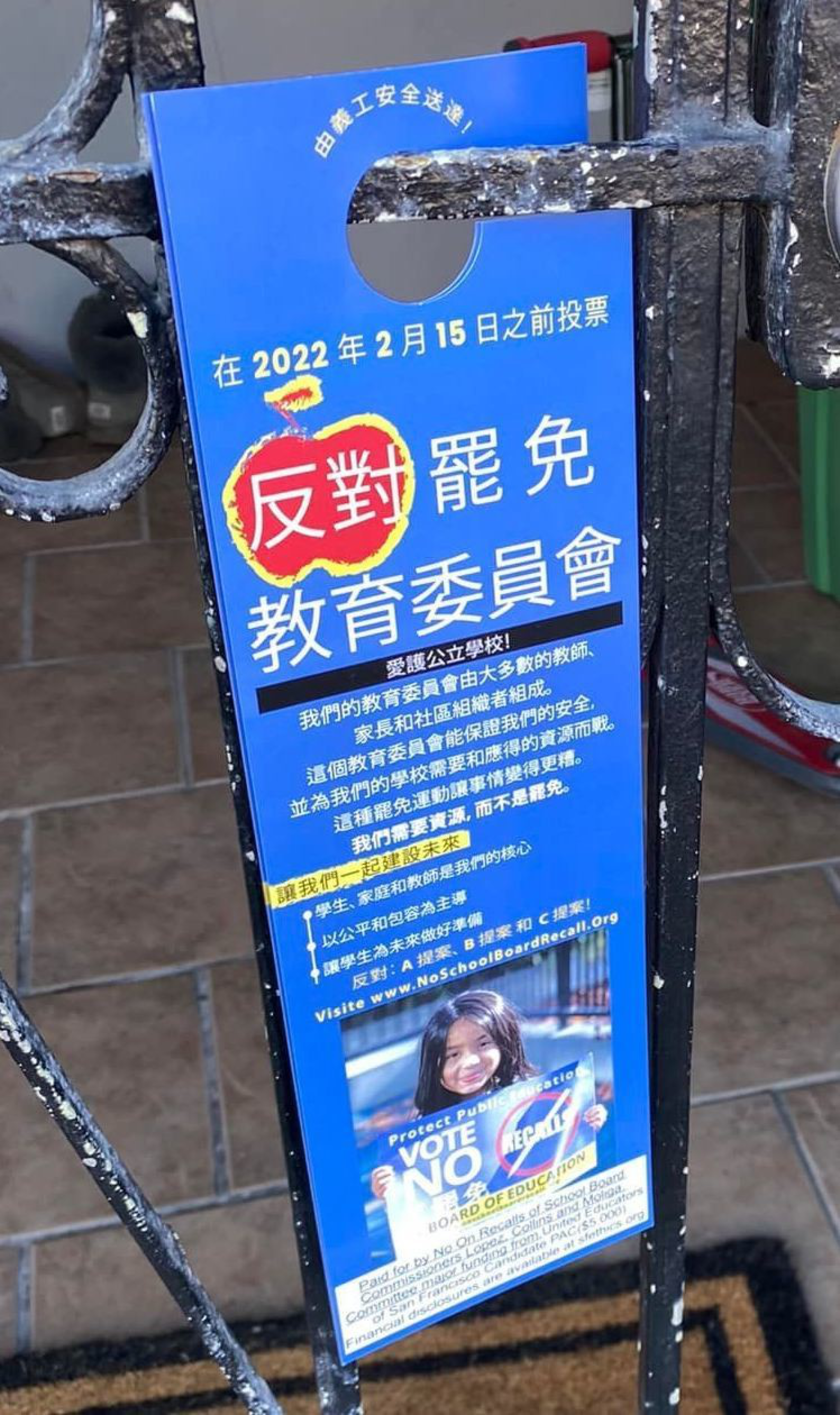 A blue door hanger with Chinese text urges voting "NO" to recall an education board, featuring a smiling child holding a sign that says "VOTE NO RECALL."