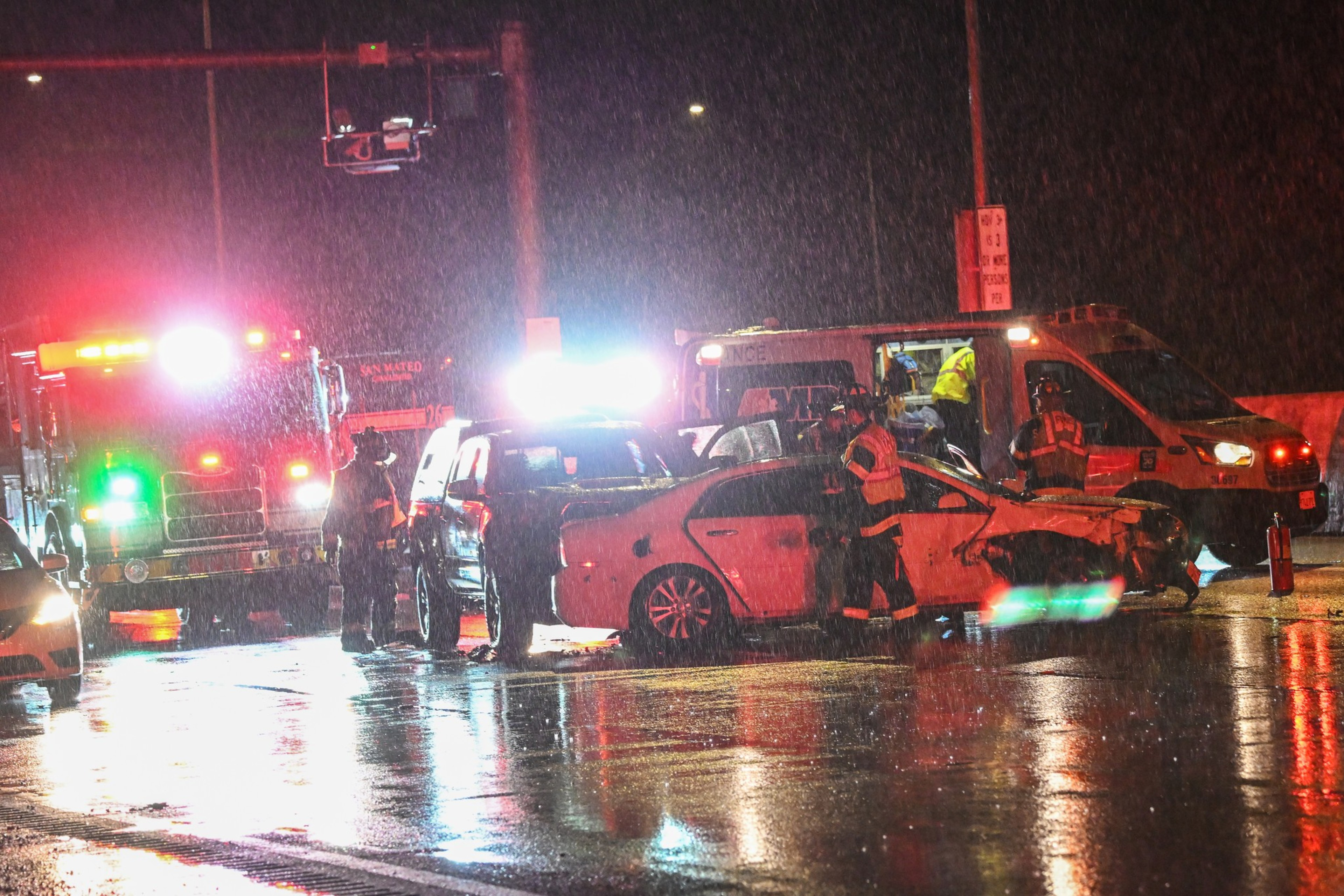 Emergency responders surround a crashed car.