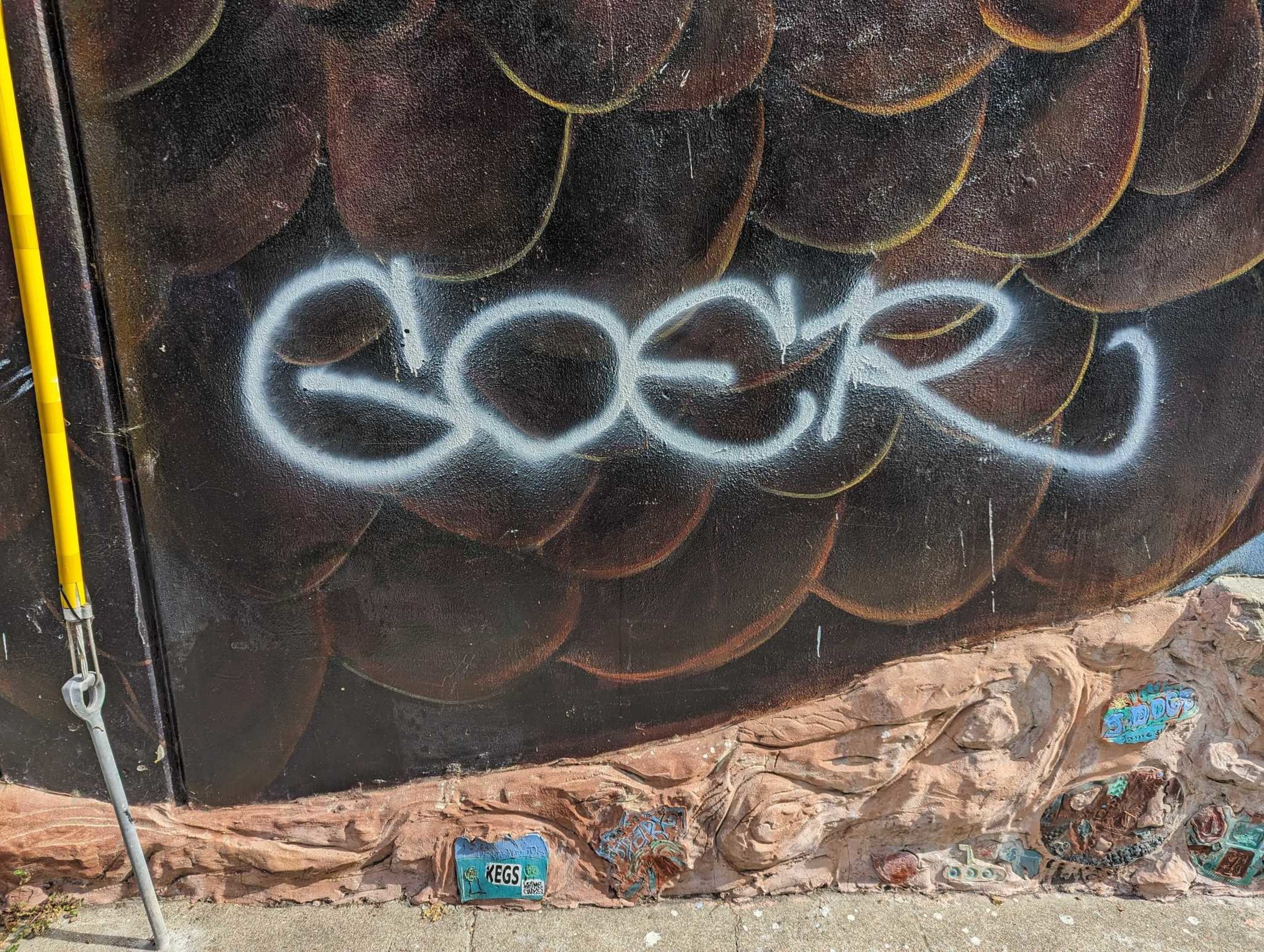 On a Langton Street wall south of Folsom Street in San Francisco's South of Market neighborhood, a gray-spray painted graffiti tag mars a bald eagle's plumage in a neighborhood mural.