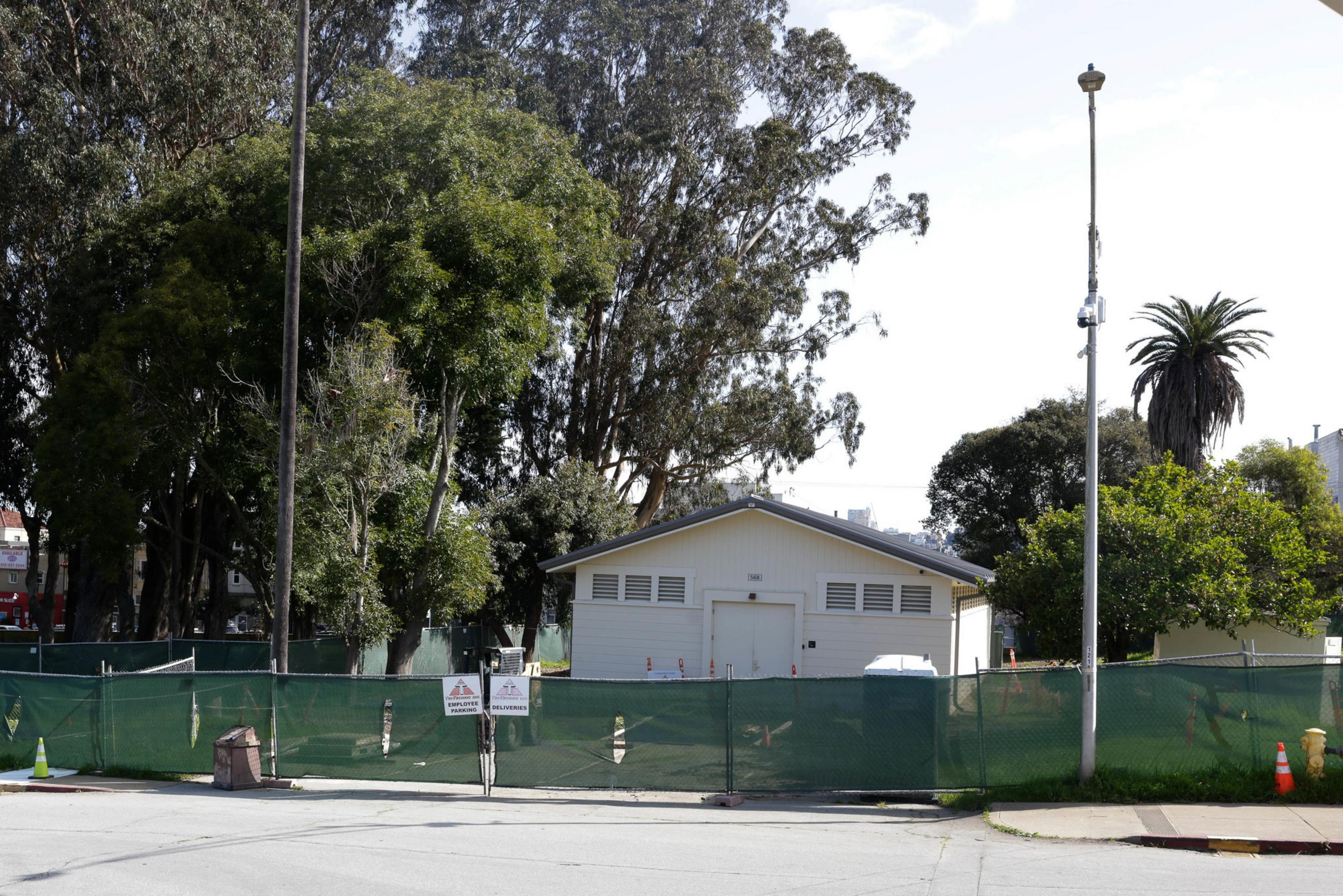 A fence sitting in front of a construction site is seen in a photograph