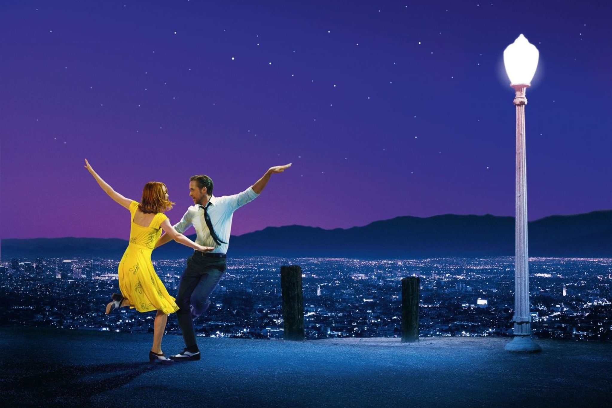 A couple dances joyfully on a hilltop at night, with city lights below, a starry sky above, and a single glowing streetlamp nearby.