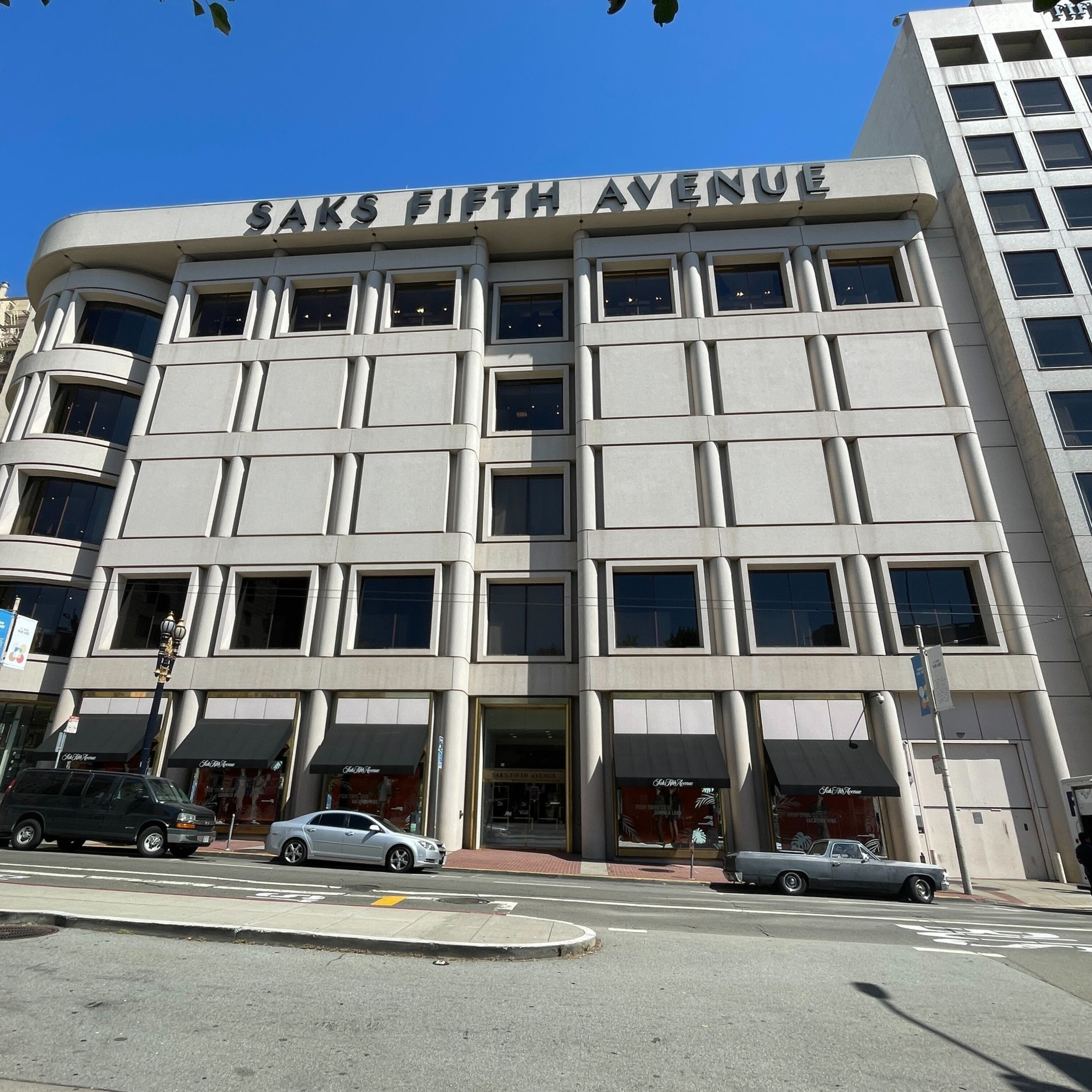 A bright blue sky above a five-story building, with the words Saks Fifth Avenue across the top.