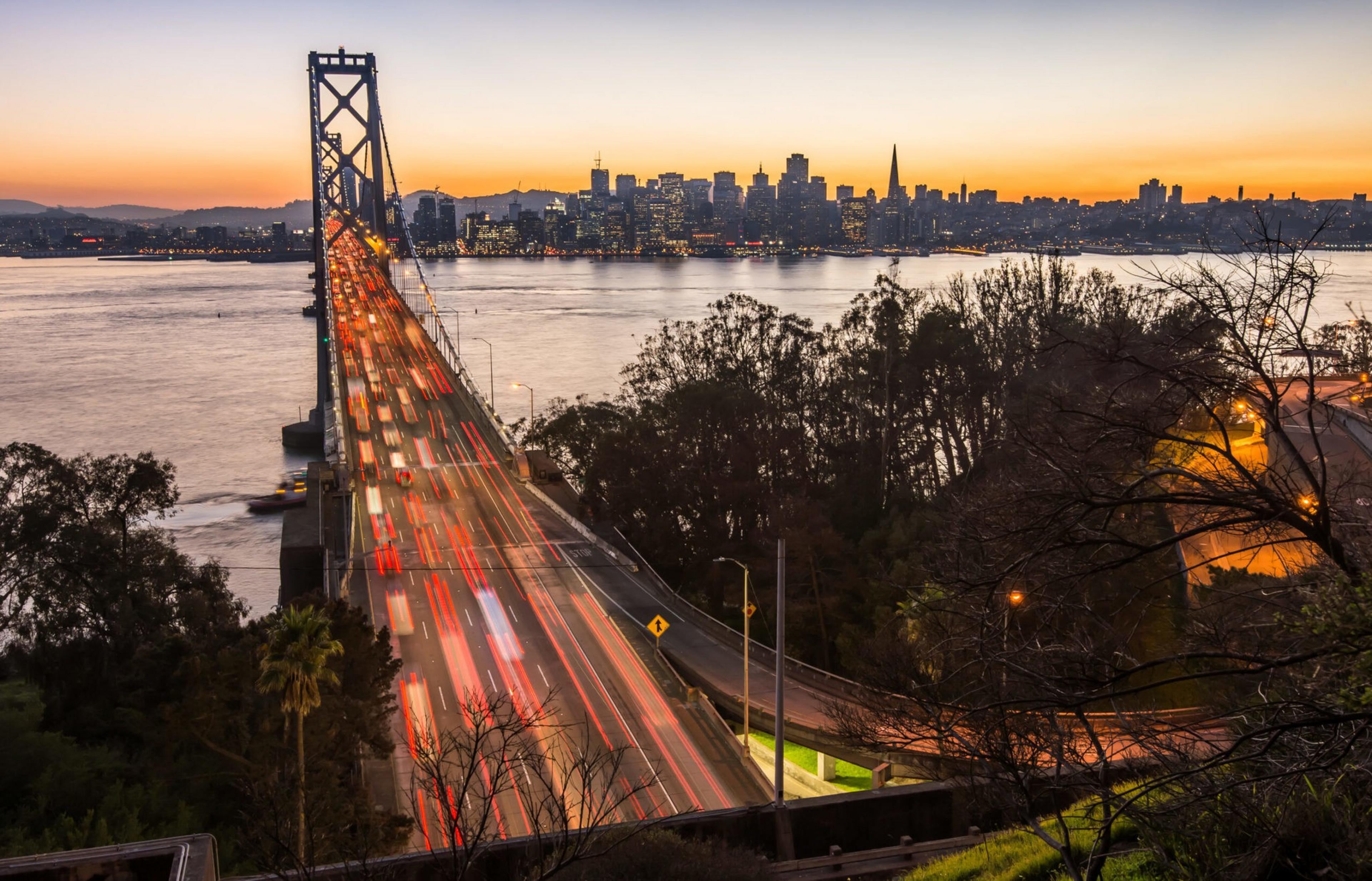 The Bay Bridge at dusk with vehicles crossing it