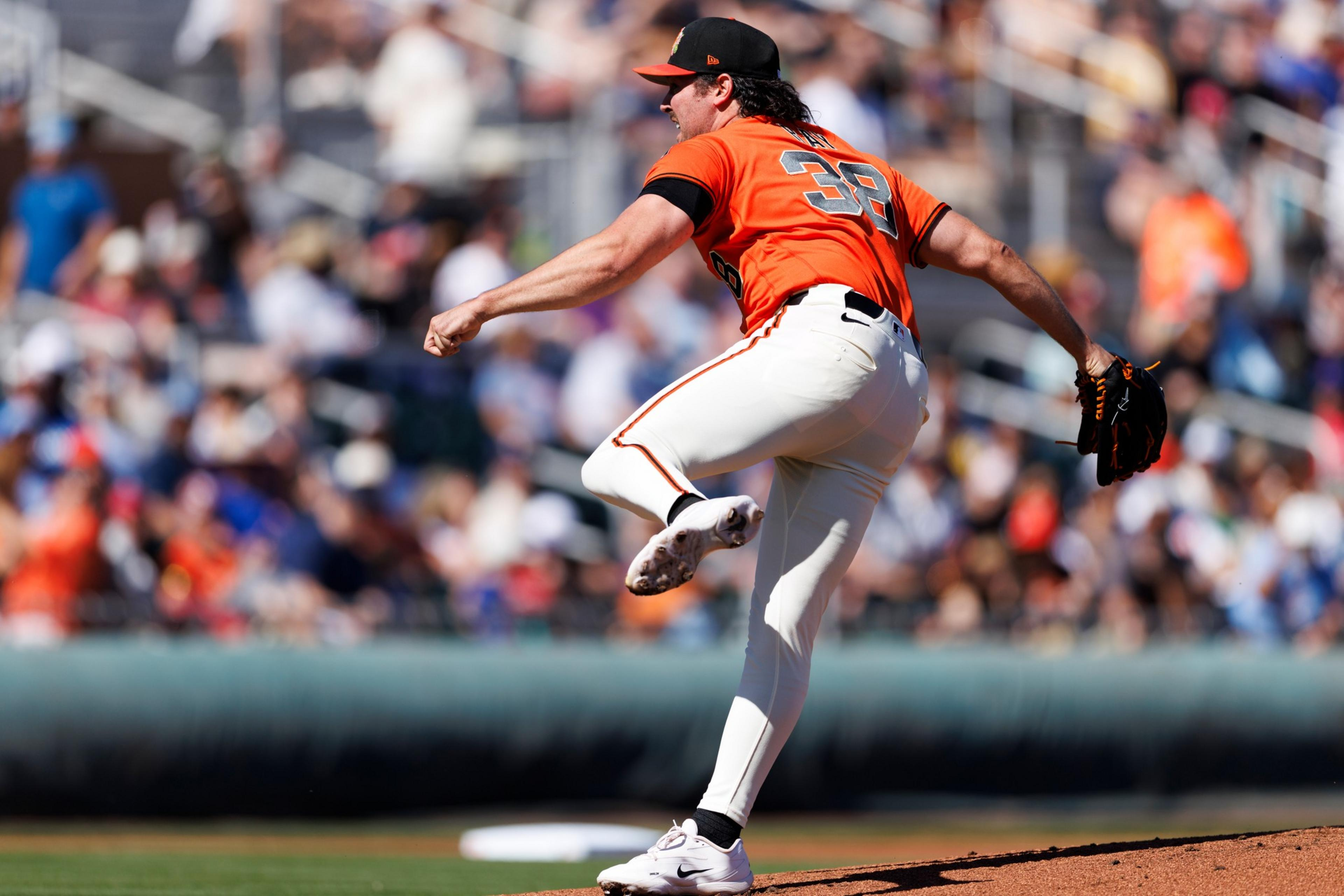 A baseball pitcher wearing an orange jersey with number 38 and white ...