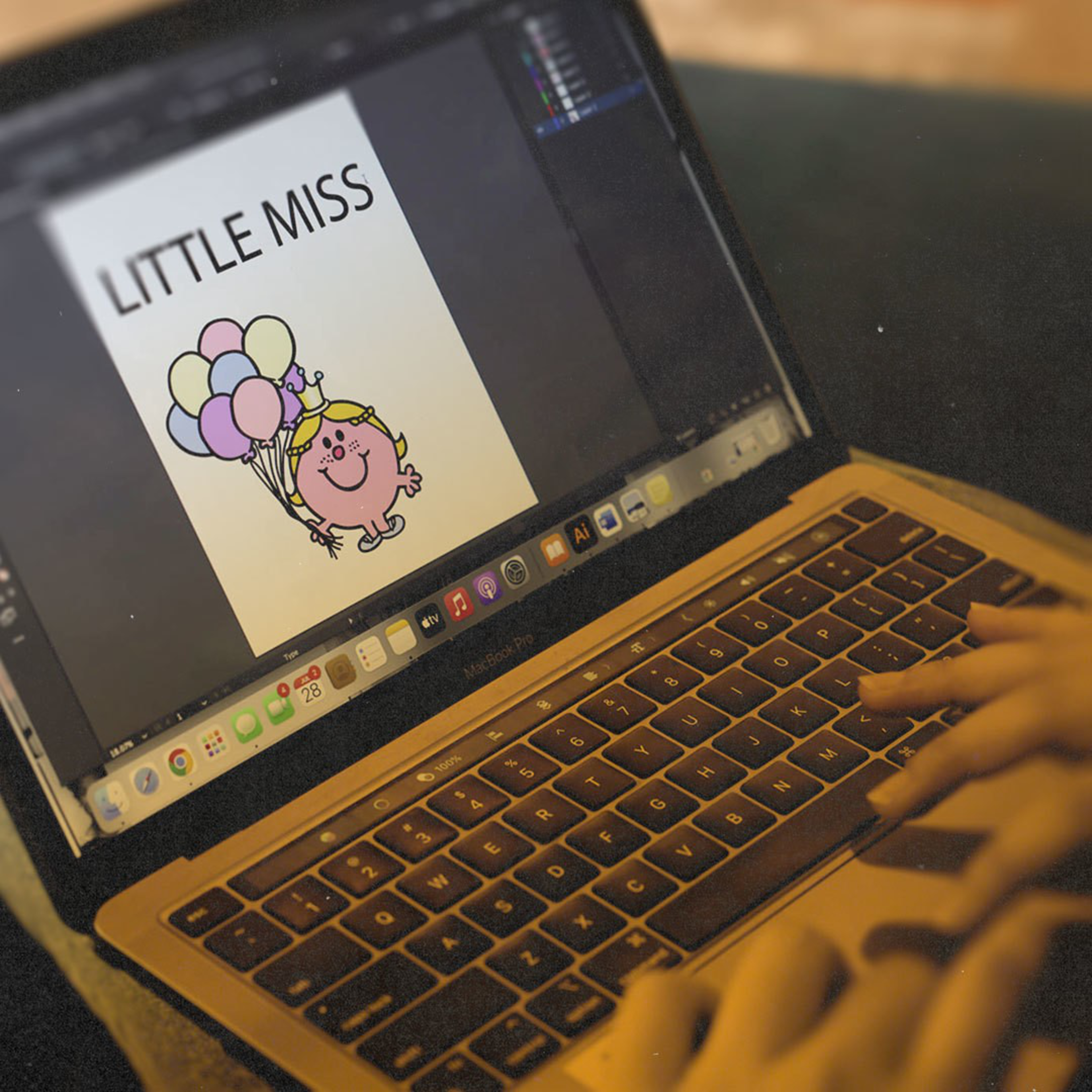 A person types on a MacBook Pro displaying a digital drawing of a pink round character holding balloons with the text "LITTLE MISS."